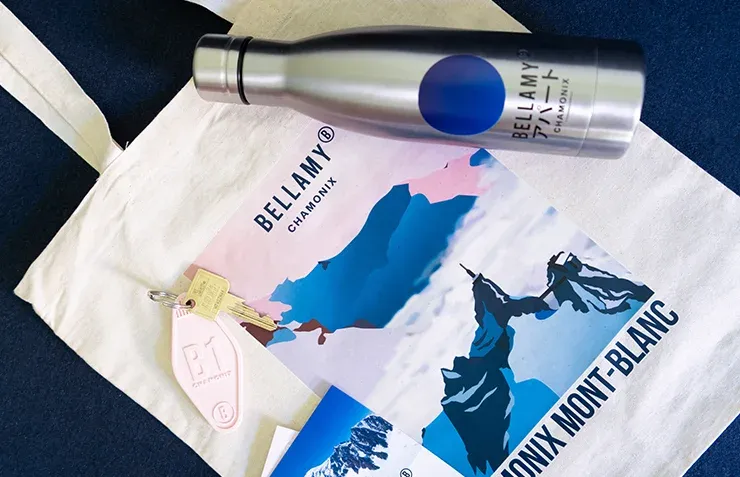 Un tote bag et une bouteille thermos floqués à l'effigie des Appartements Bellamy Chamonix, ainsi qu'une clé de chambre.