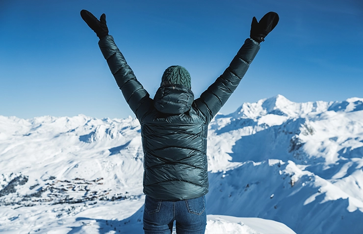 Femme face à la vue au sommet des pistes
