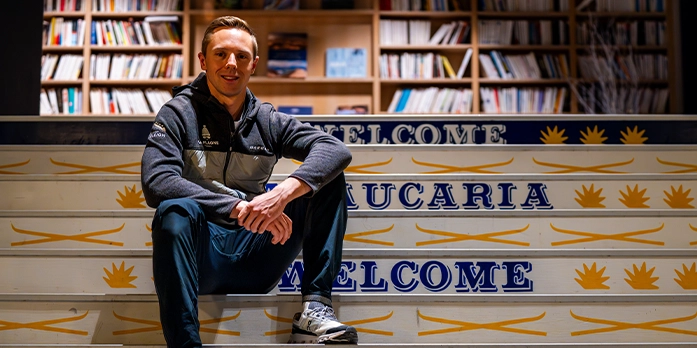 Lucas Defayet assis sur les marches du hall de l'hôtel Araucaria