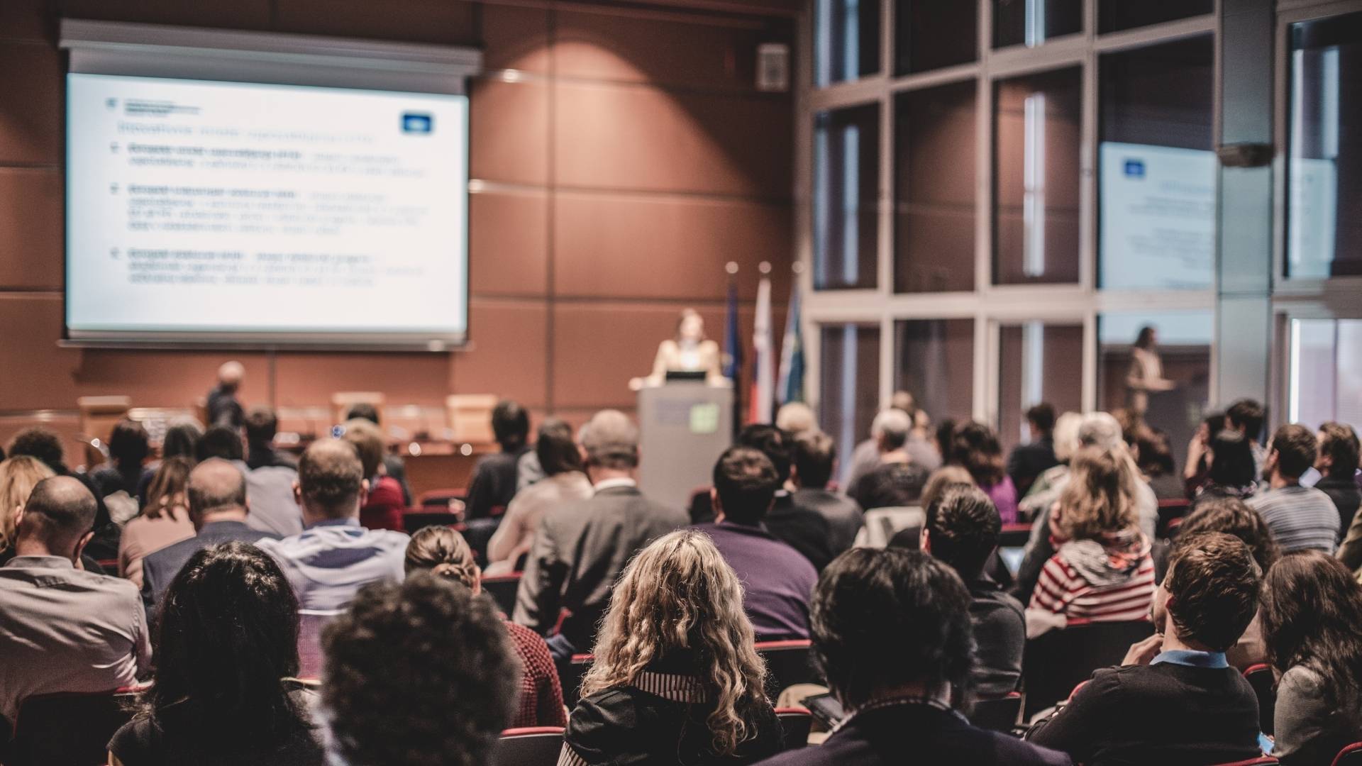 Teilnehmende einer Firmenschulung folgen einer Präsentation im Seminarraum