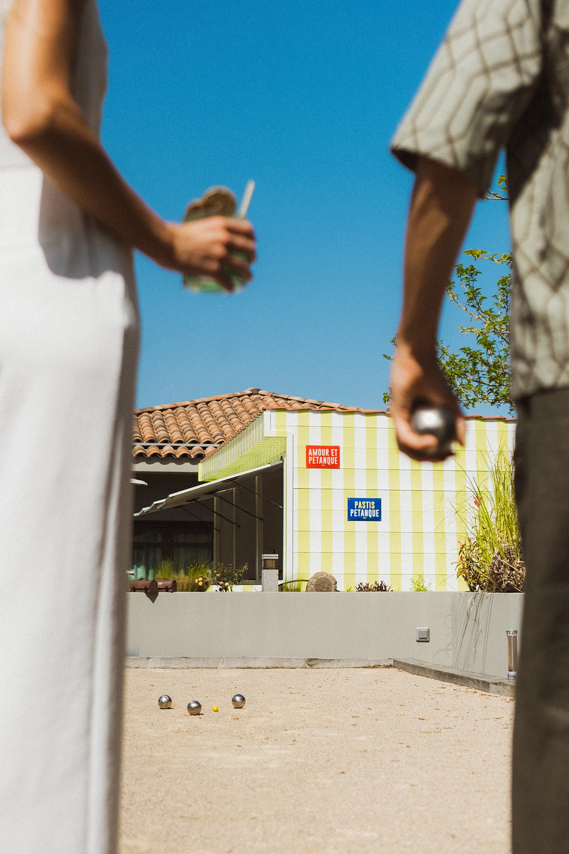 Partie de pétanque conviviale entre amis lors d'un apéritif au Kube Hôtel Saint-Tropez, expérience authentique sous le soleil de Provence.