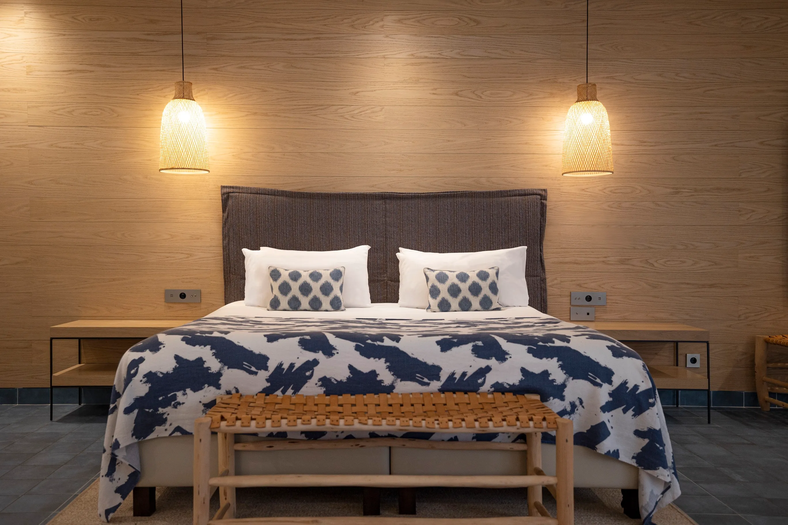 Grand lit double king size avec éclairage tamisé et tête de lit en bois, chambre Junior Ibiza.