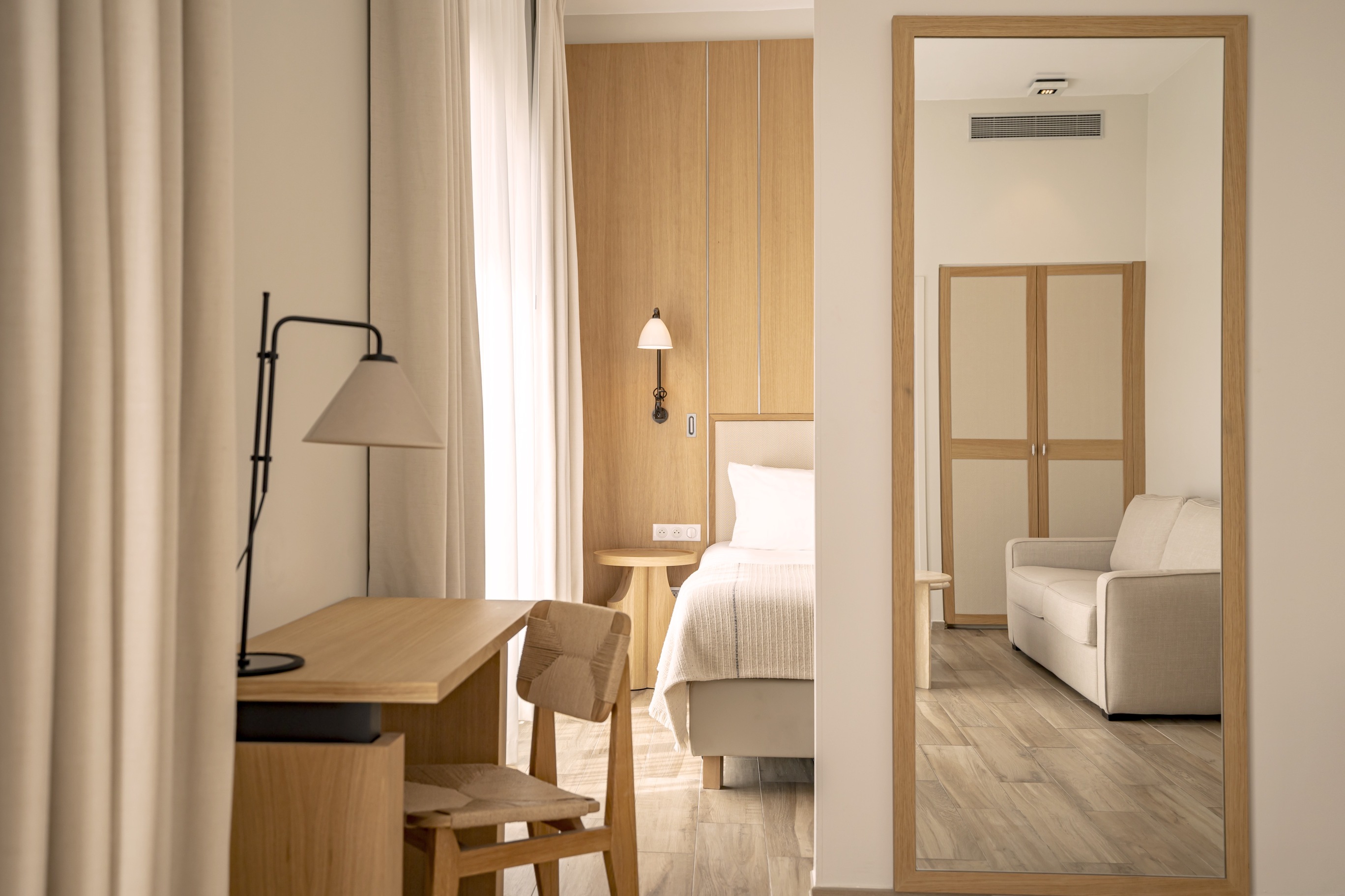 Espace bureau élégant avec miroir de plein pied et mobilier sur-mesure dans une suite Prestige lumineuse.