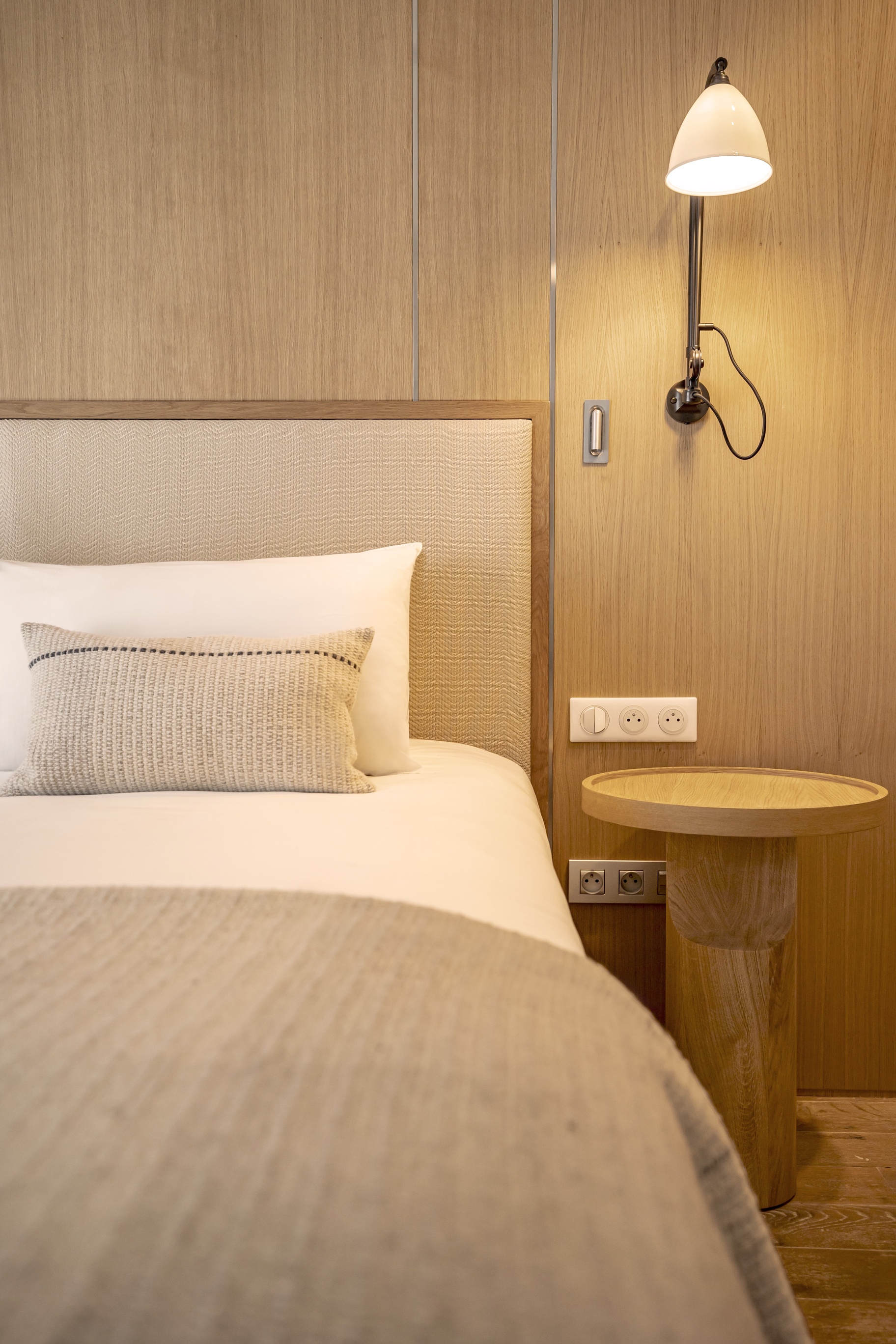 Grande chambre Prestige avec dressings intégrés en bois clair, climatisation discrète et décoration épurée haut de gamme.