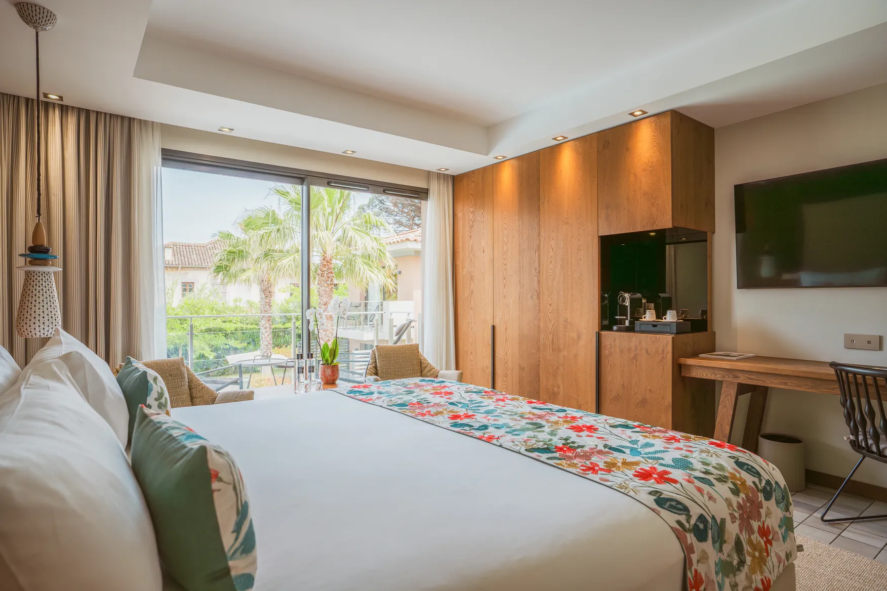hambre Ibiza chic avec éclairage d'ambiance chaleureux, jeté de lit bleu et blanc et ouverture directe sur un patio privé.