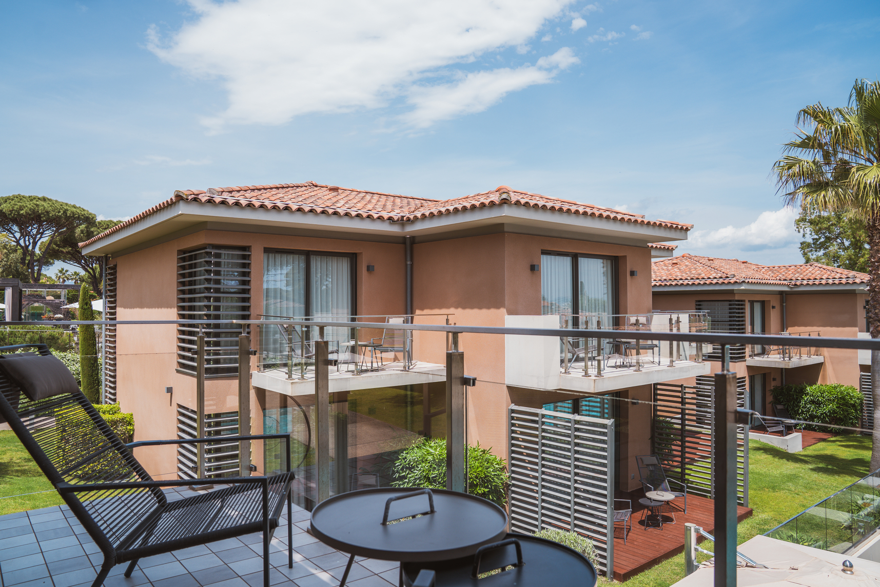 Espace extérieur de la suite avec fauteuils de jardin design et panorama sur la nature environnante.