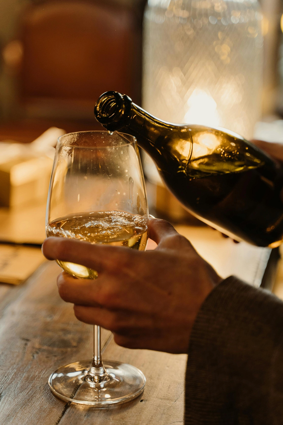 Dégustation de vin blanc de Provence servi au verre dans l'ambiance tamisée d'une cave de Saint-Tropez.