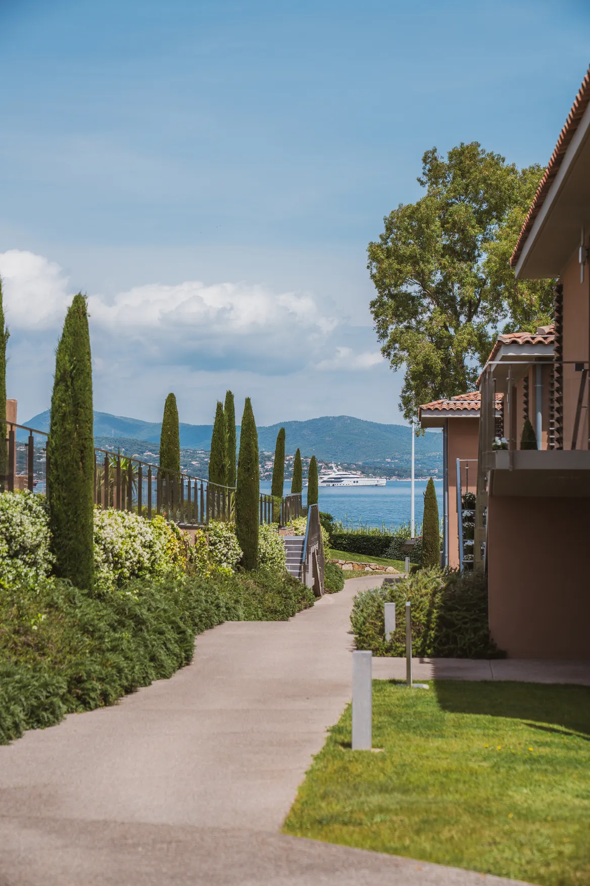 Allée fleurie et jardins méditerranéens de l'Hôtel Kube Saint-Tropez avec vue sur la mer.