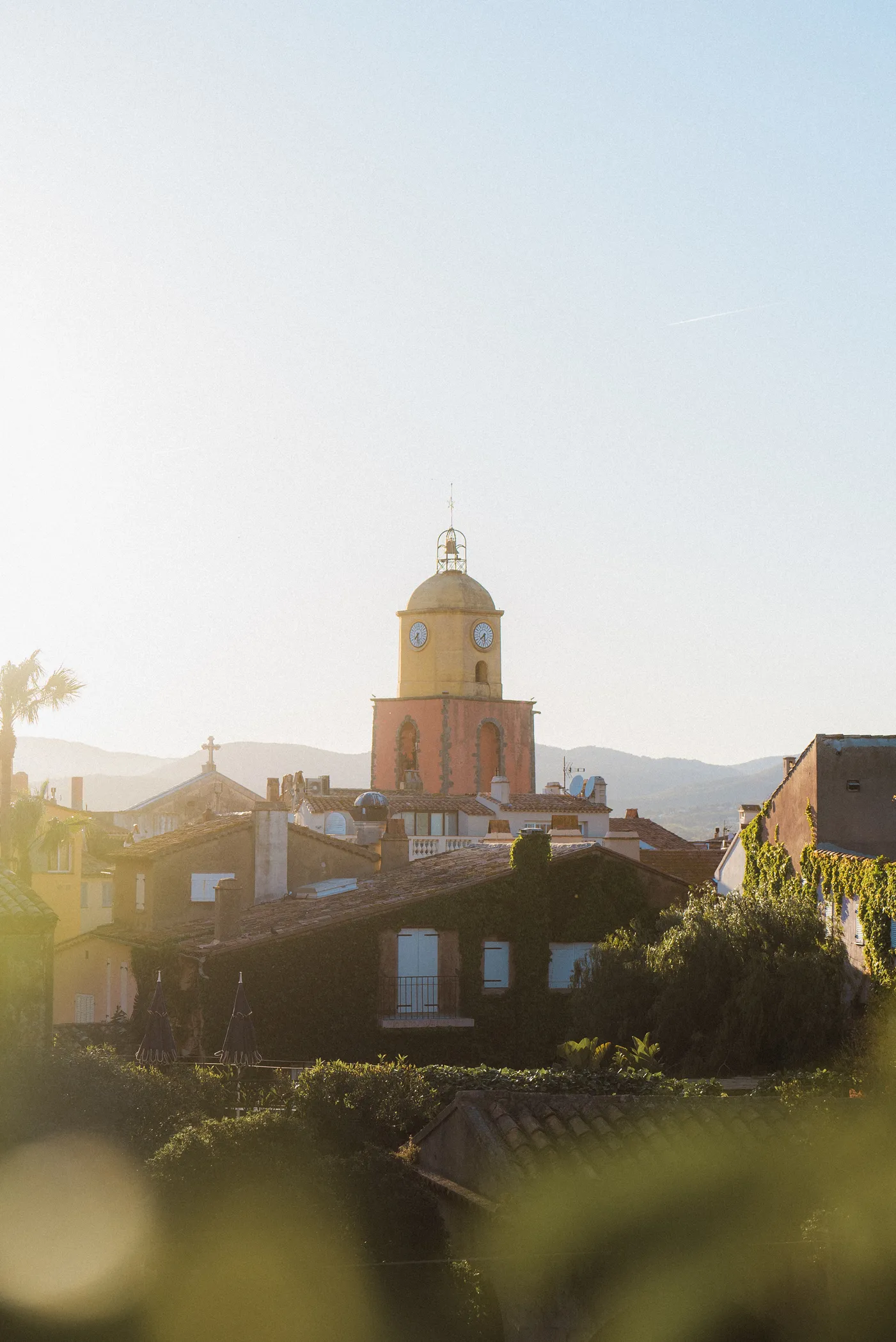 Le célèbre clocher de l'église de Saint-Tropez aux couleurs ocre et jaune sous la lumière dorée.