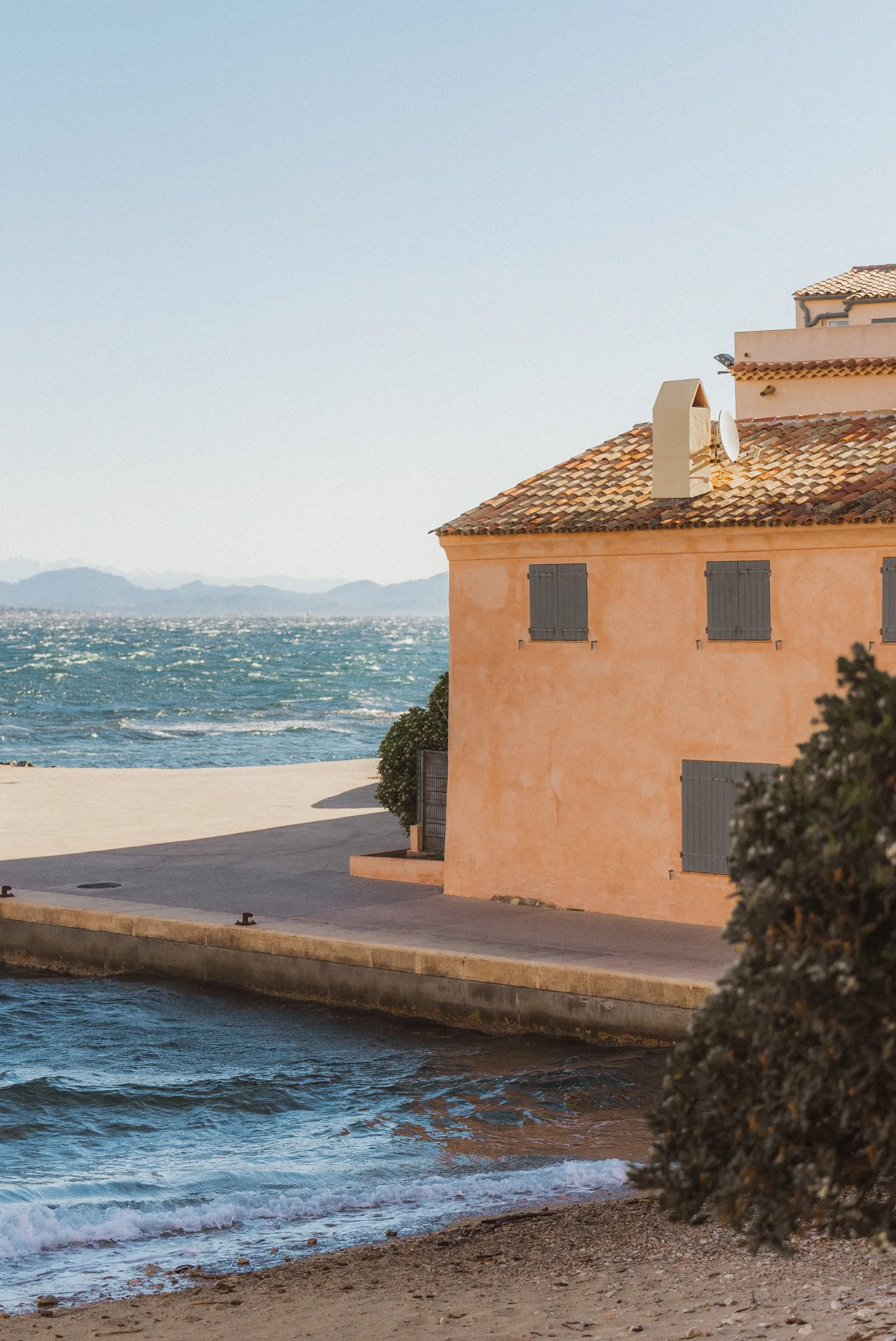 Maison ocre typique du quartier de la Ponche au bord de l'eau à Saint-Tropez, vue sur la mer Méditerranée et la vieille ville.