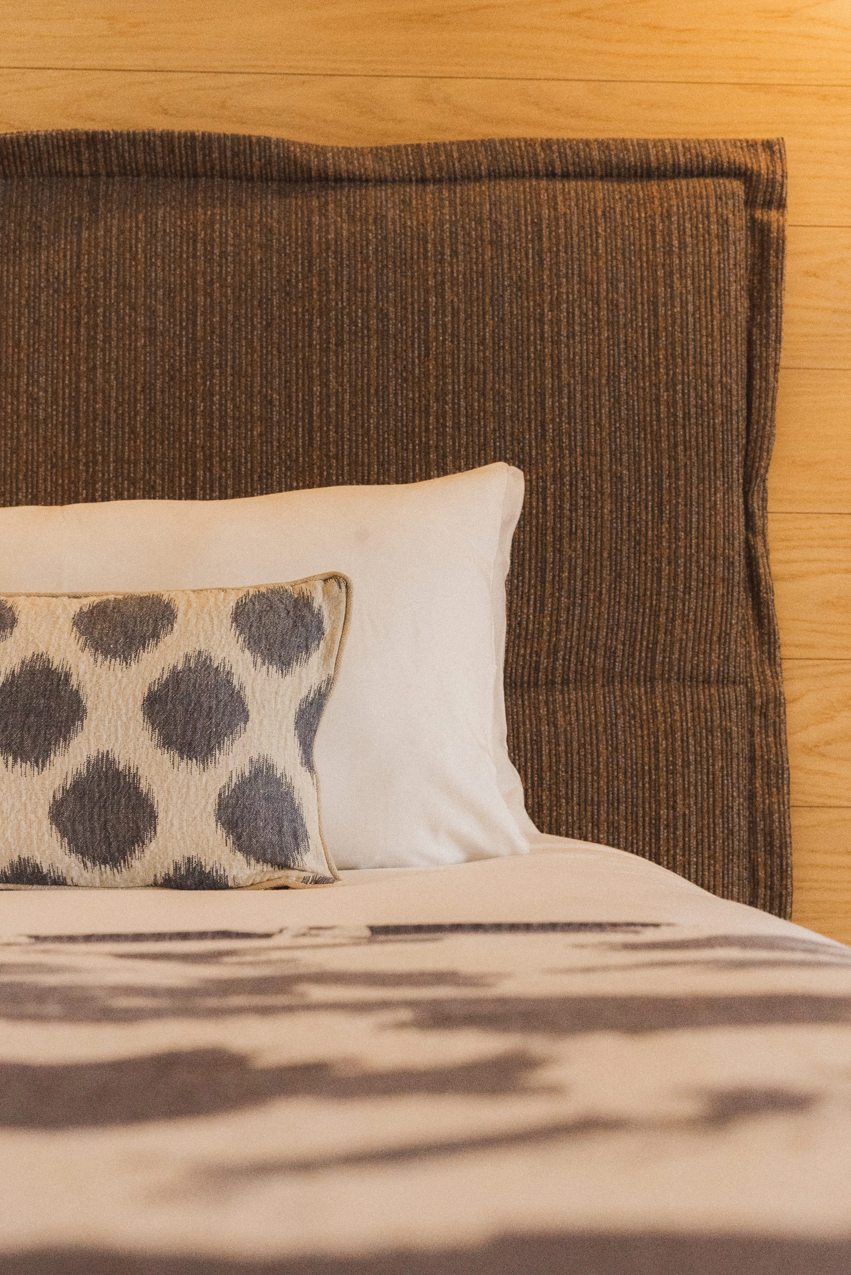 Détail de la tête de lit rembourrée et d'un coussin à motifs dans la chambre Prestige Ibiza