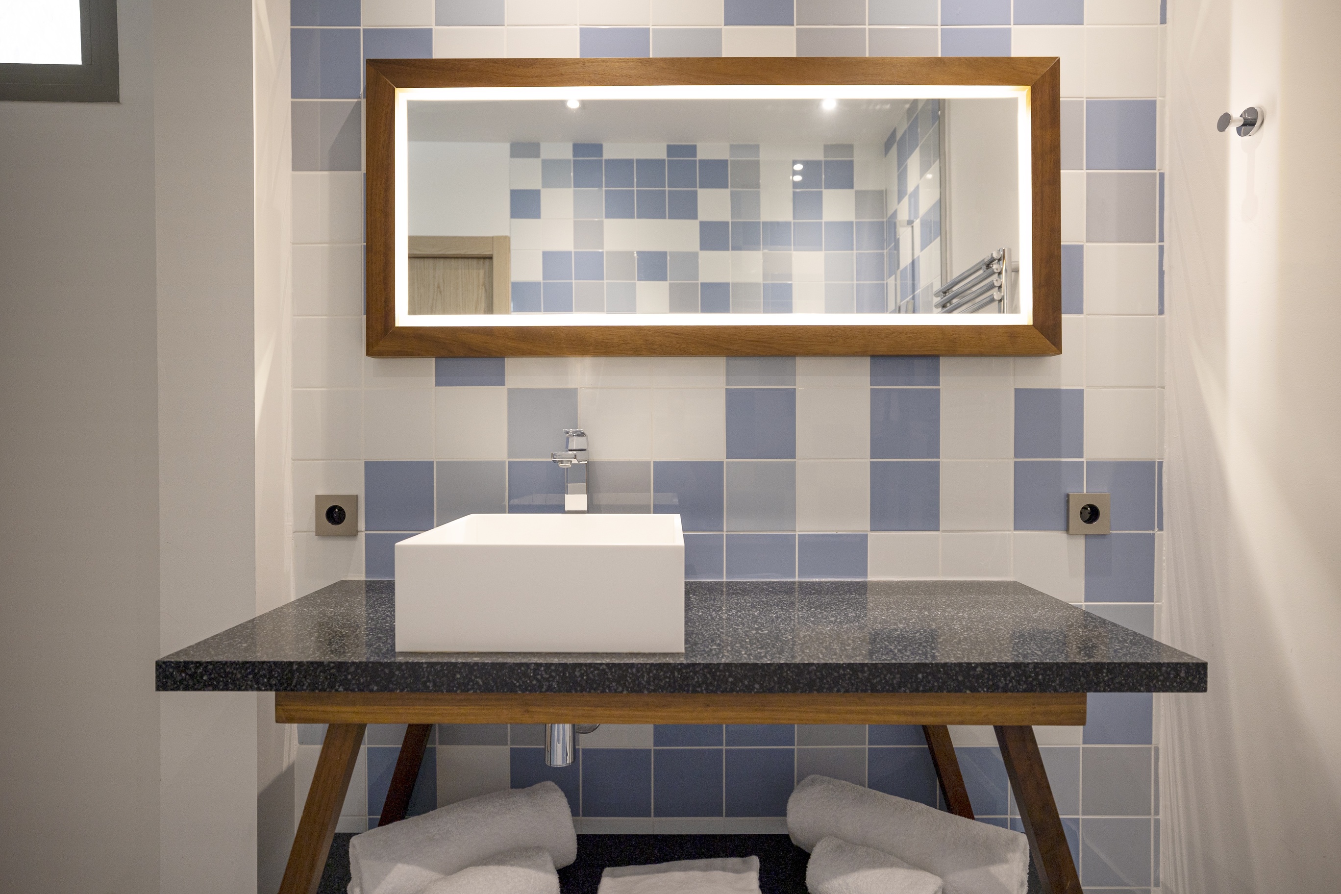 Meuble vasque design en bois et grand miroir sur fond de faïence bleue, salle de bain Junior Ibiza.