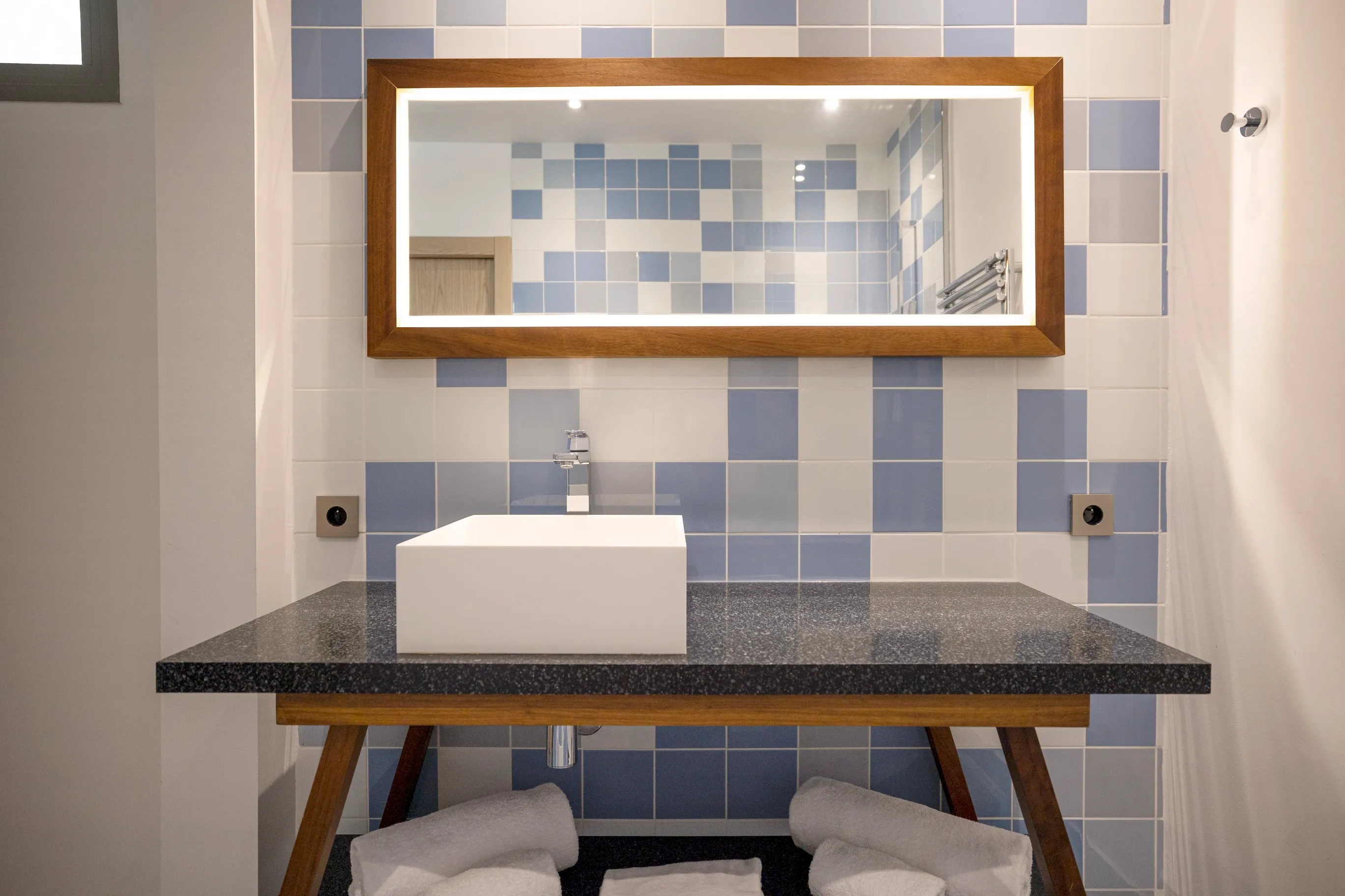 Meuble vasque design en bois et grand miroir sur fond de faïence bleue, salle de bain Junior Ibiza.