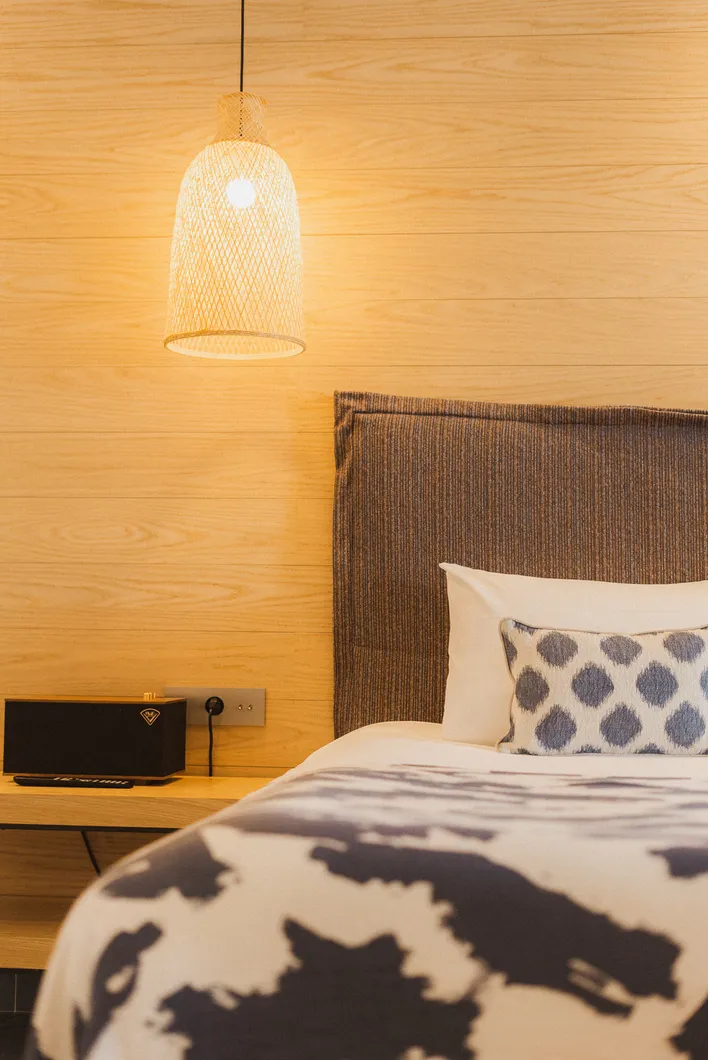 Détail de la tête de lit rembourrée et d'un coussin à motifs dans la chambre Prestige Ibiza.
