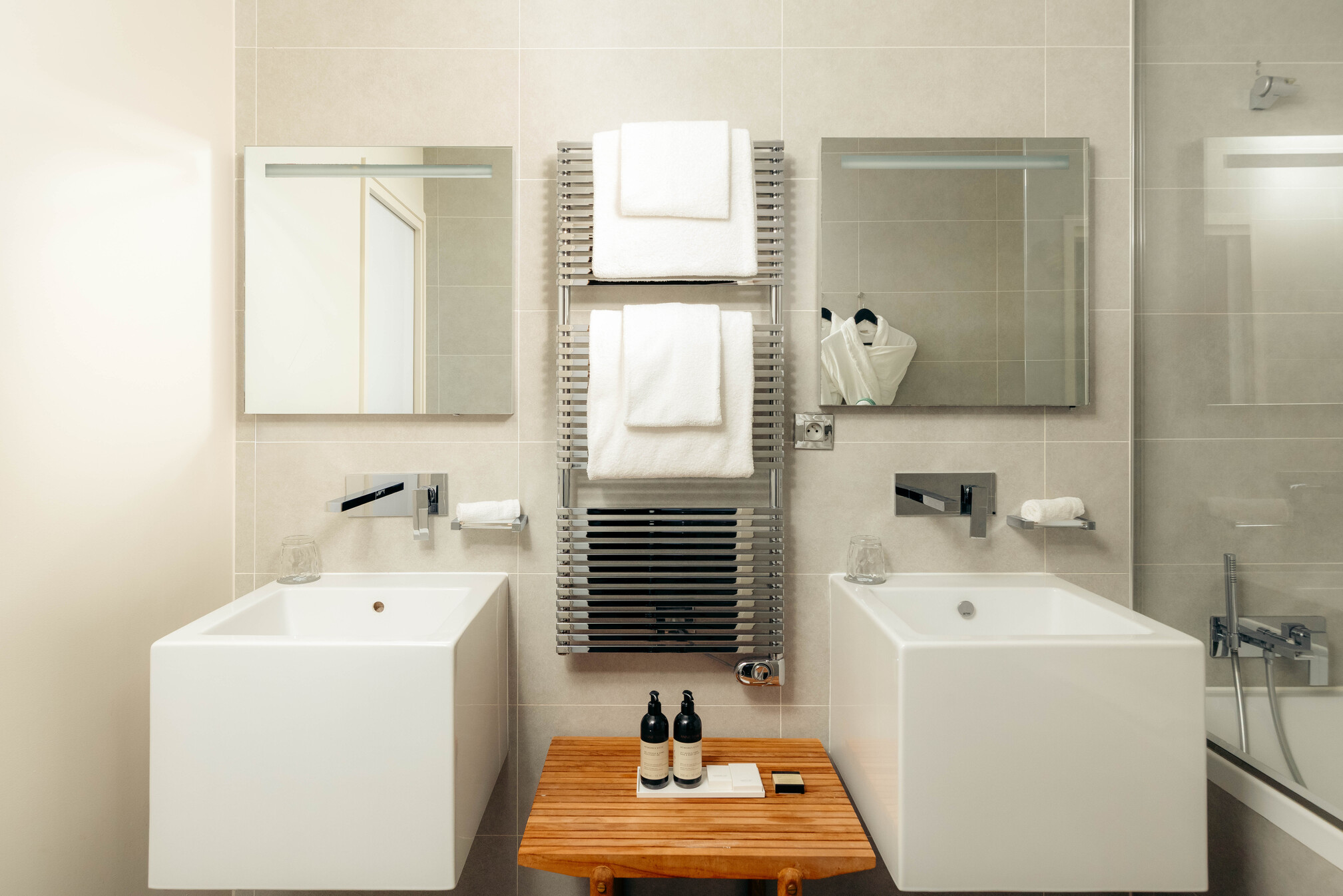 Salle de bain haut de gamme de la suite Prestige Natural Sea avec deux vasques colonnes blanches modernes et miroirs.