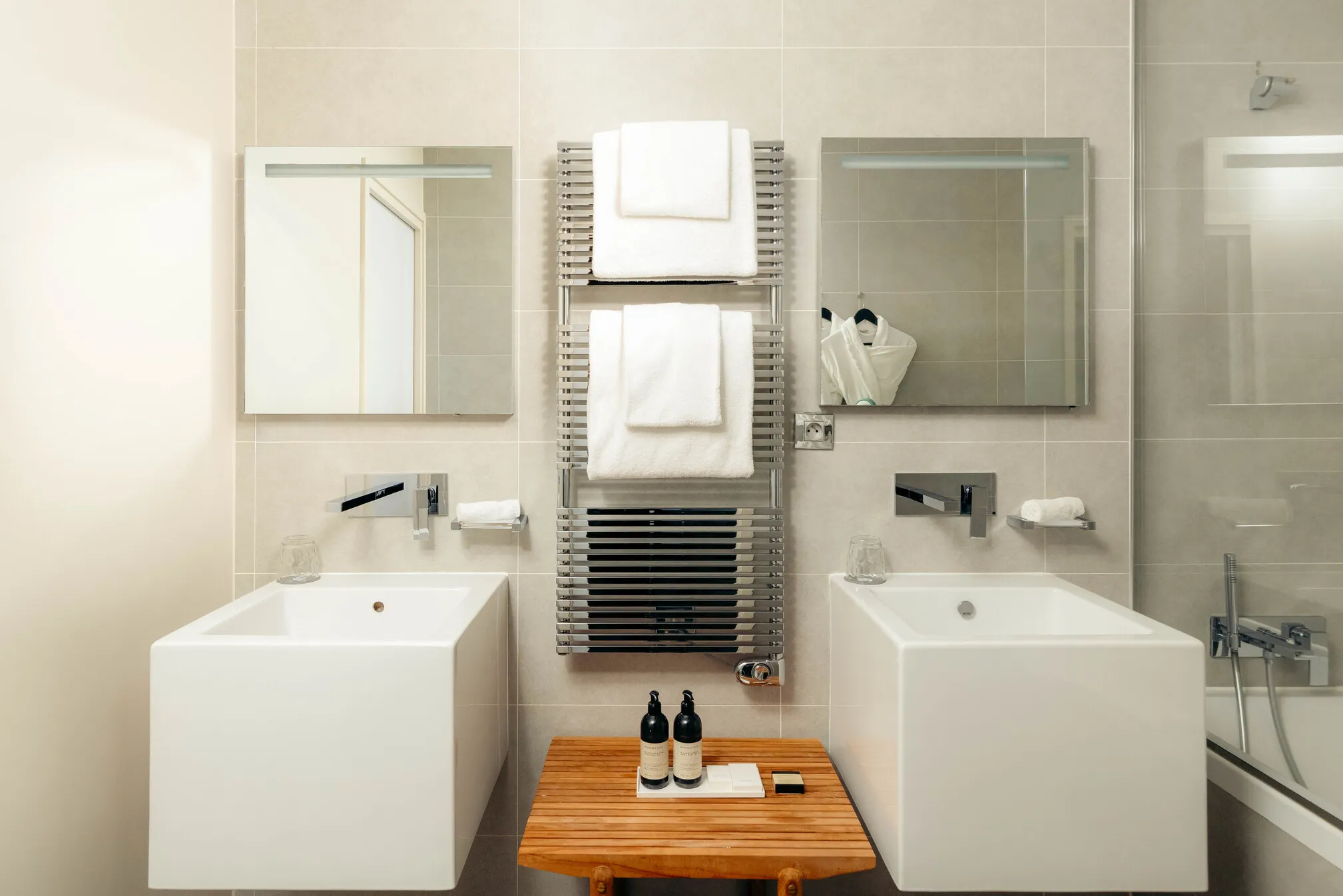 Salle de bain haut de gamme de la suite Prestige Natural Sea avec deux vasques colonnes blanches modernes et miroirs.