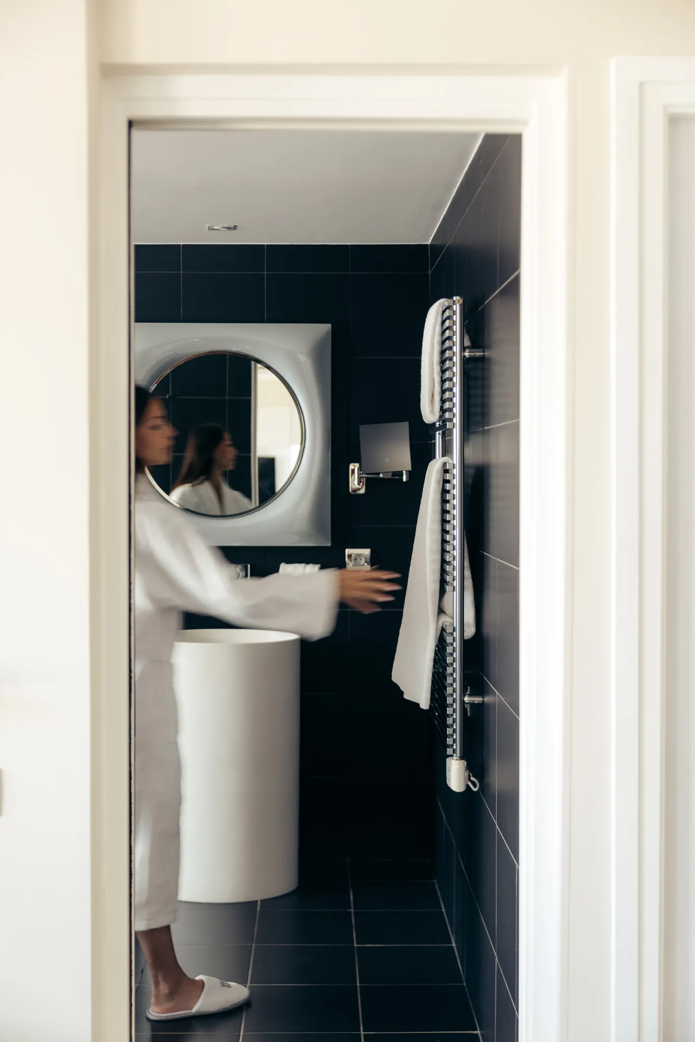 Perspective sur la salle de bain moderne et épurée de la Suite Natural Sea & Spa depuis l'entrée.