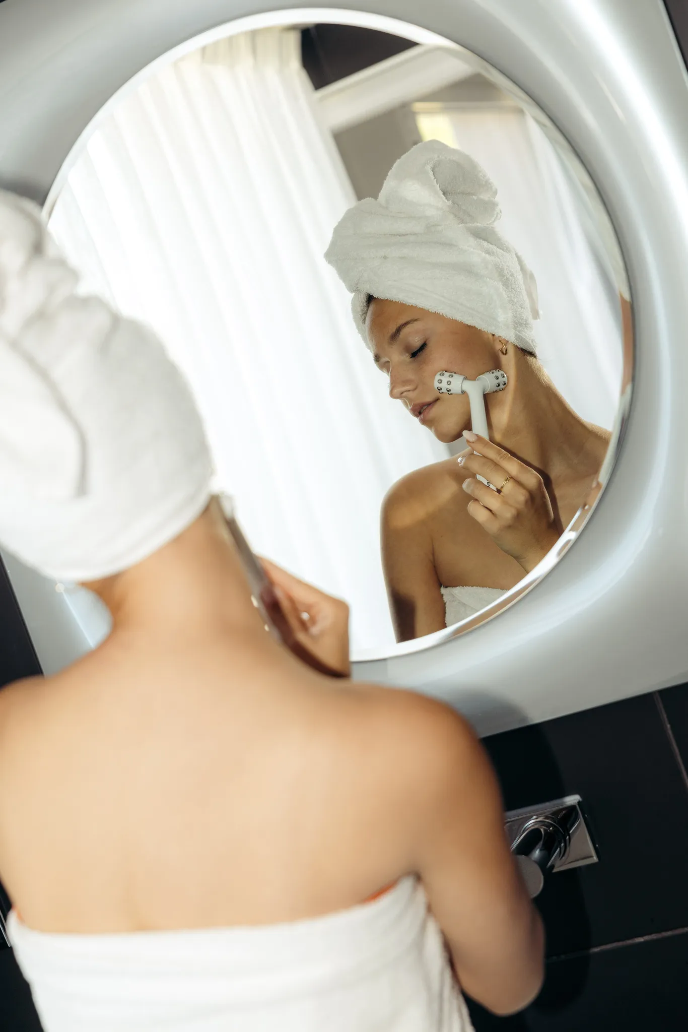 Moment de soin et de bien-être face au miroir de la salle de bain dans la Suite Natural Sea & Spa.