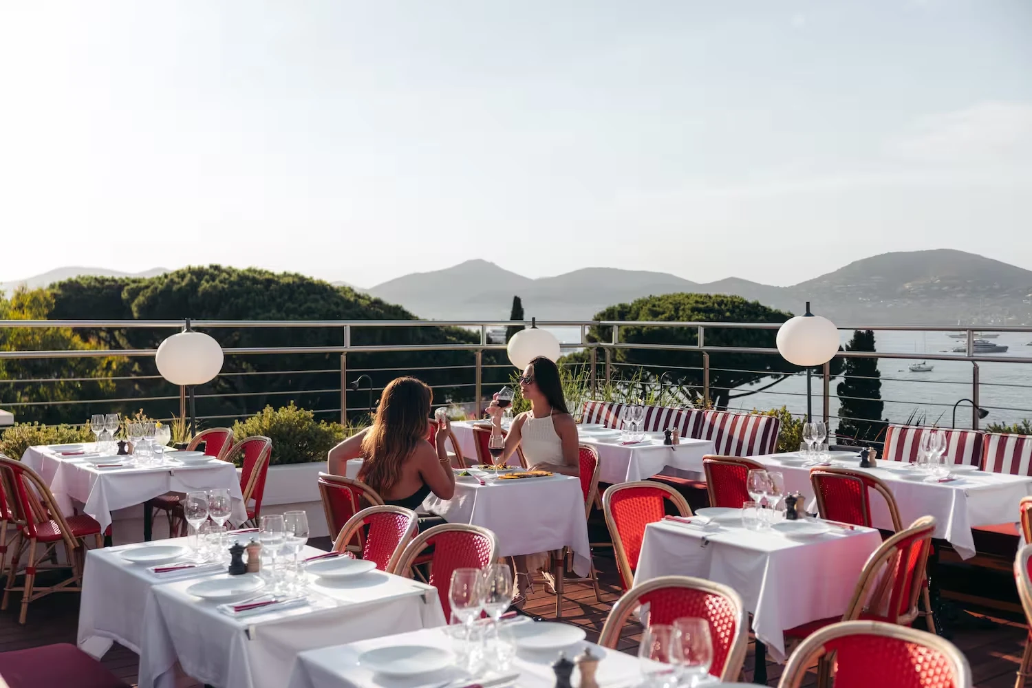 Tables set on a terrace facing the Gulf of Saint-Tropez