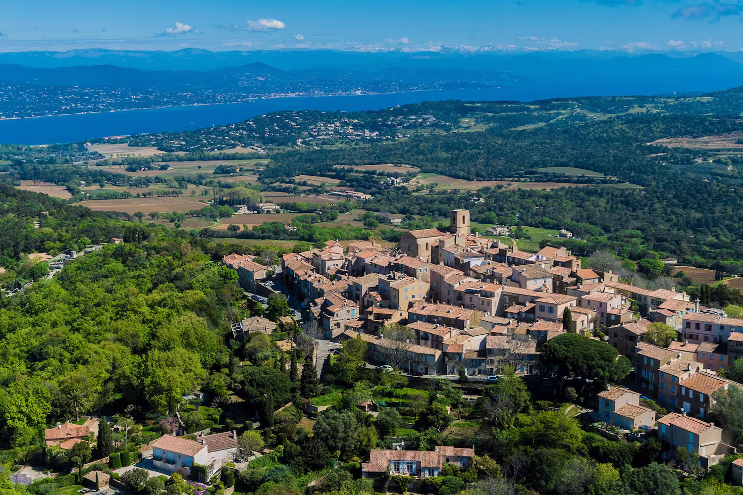 The hilltop village of Gassin from the air, surrounded by vineyards, the gulf of Saint-Tropez beyond