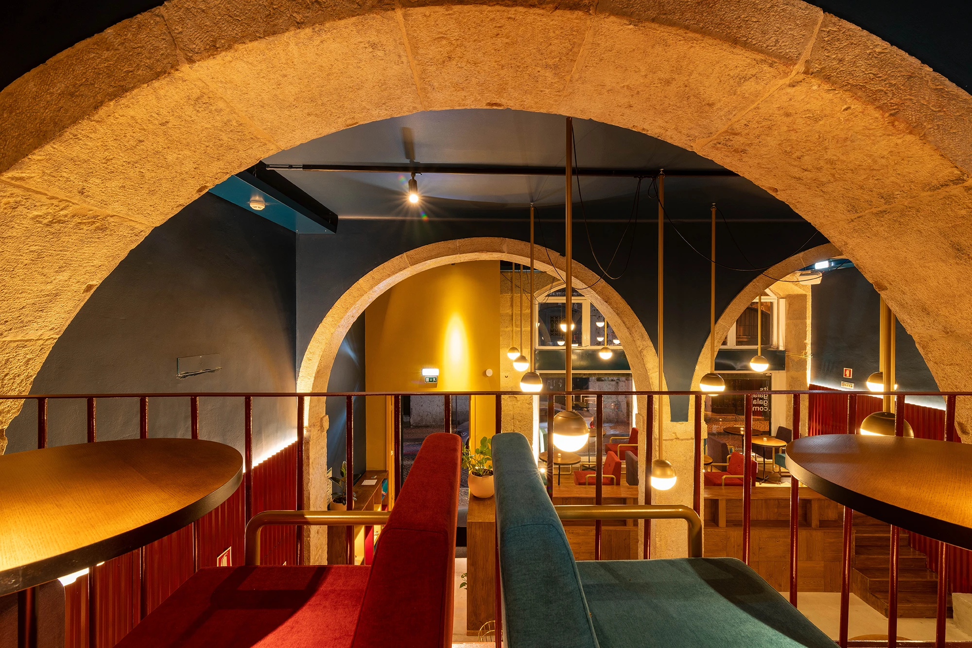 Gala Gala bar interior overview showing mezzanine level with arches and colourful seating in Lisbon
