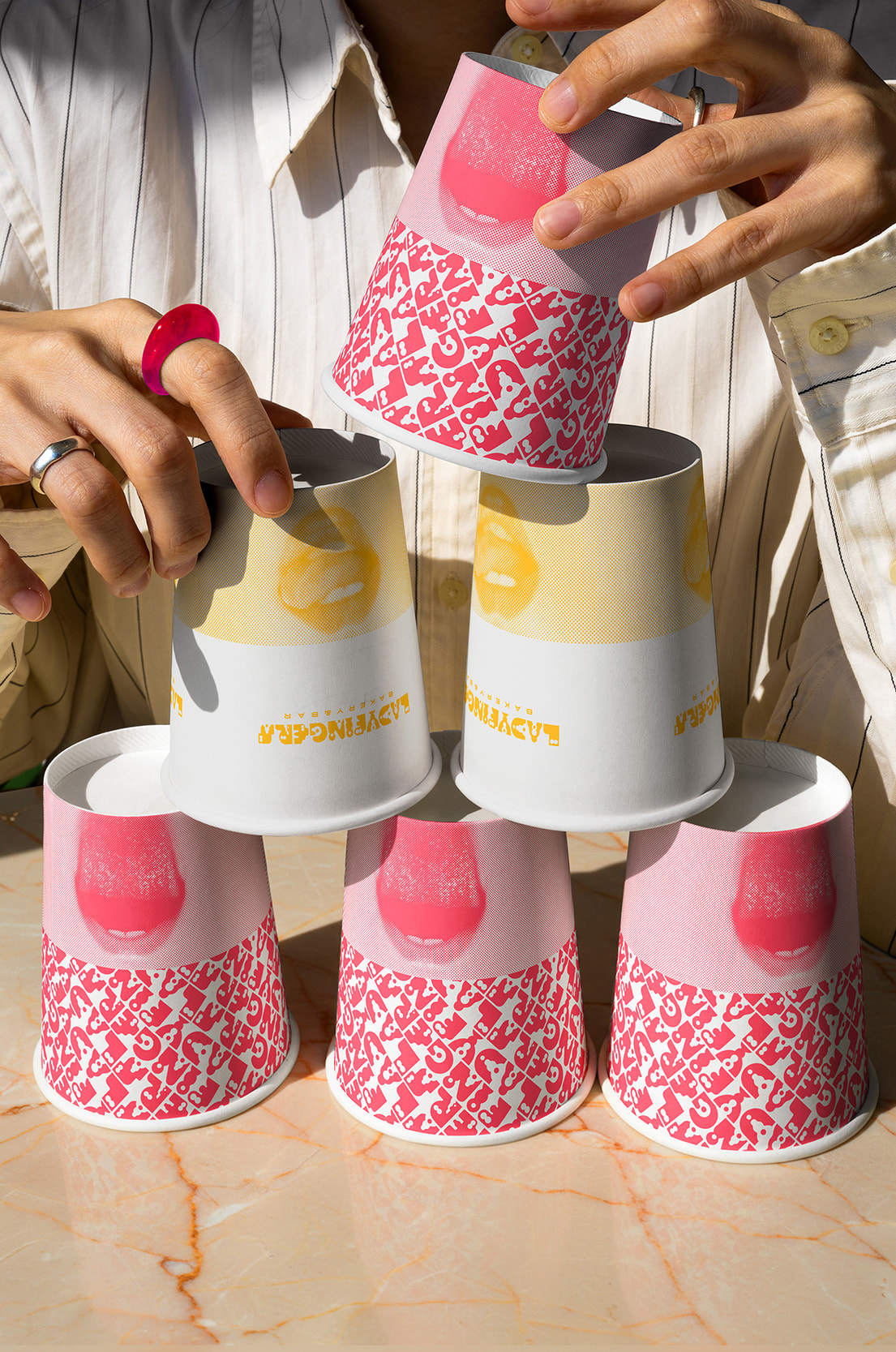 Ladyfingers branded paper cups and wrapping paper with pink pattern
