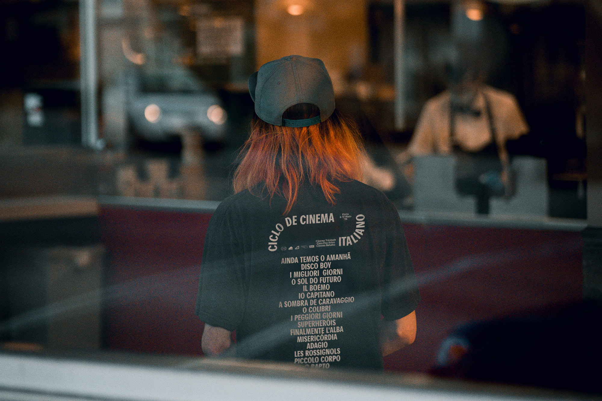 Person wearing Porto Italian Film Cycle 24 branded t-shirt with full film programme printed on the back