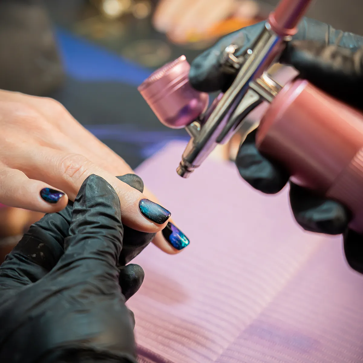 Nagelstyliste van Lakwerk brengt holografische airbrush nagelart aan op gelnagels in Amsterdam