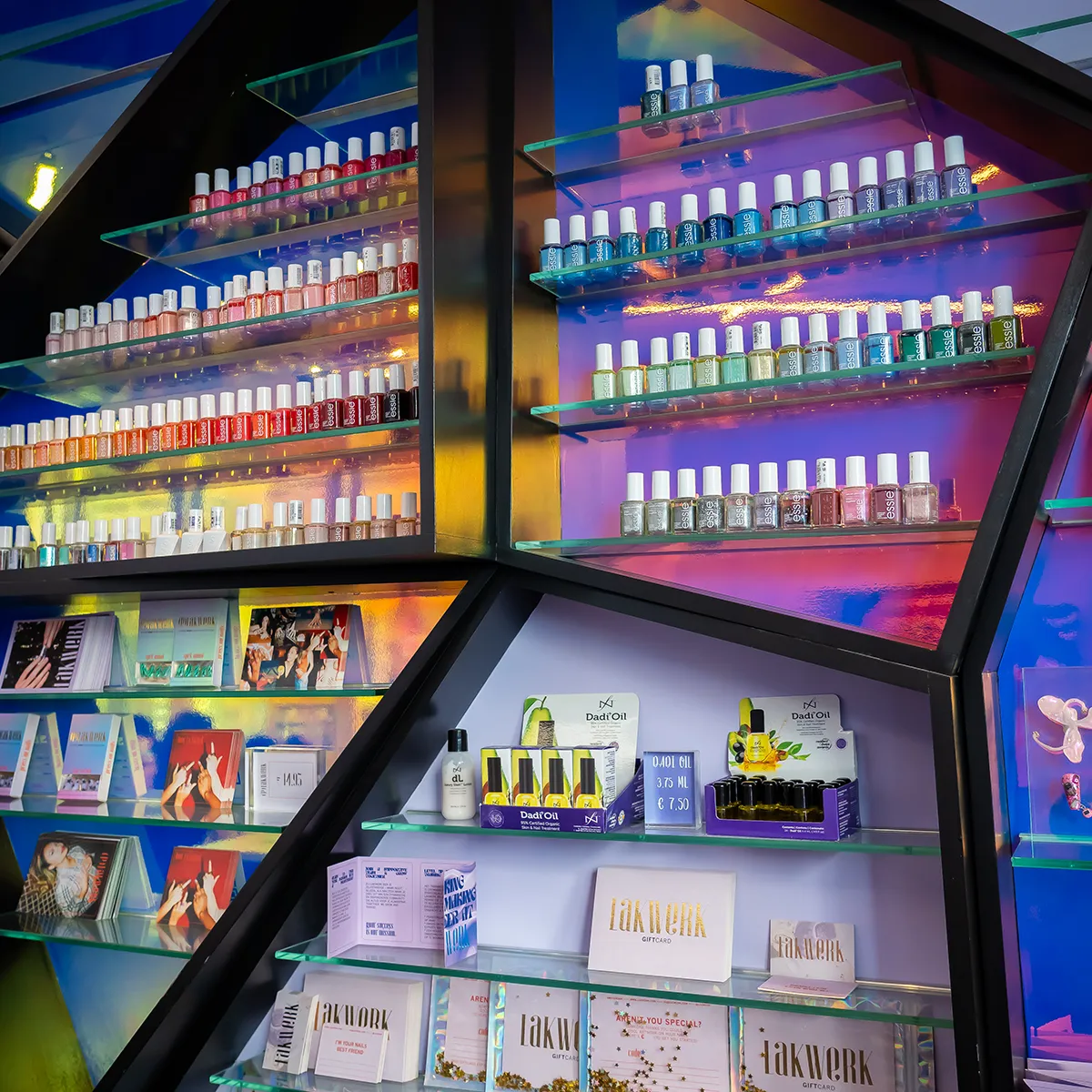 Verlichte displaykast met uitgebreide Essie nagellak collectie en Lakwerk giftcards in nagelstudio Amsterdam