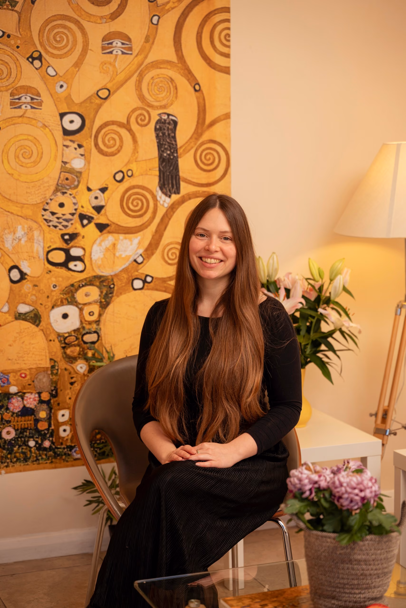 Laura-Maria Schober, embodiment coach and somatic practitioner, seated in the clinic lounge