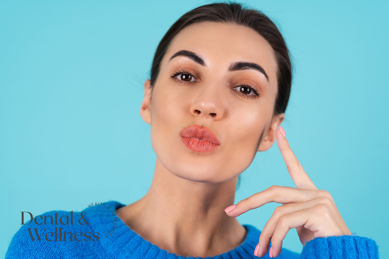 Woman pouting her lips against a blue background