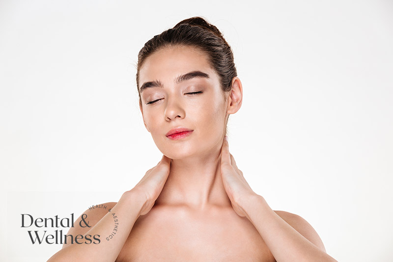 Woman gently touching her neck with her eyes closed