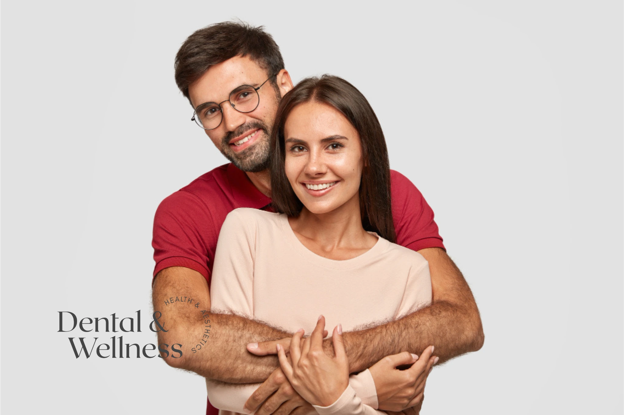 Invisalign and intimacy: smiling couple embracing against a plain background