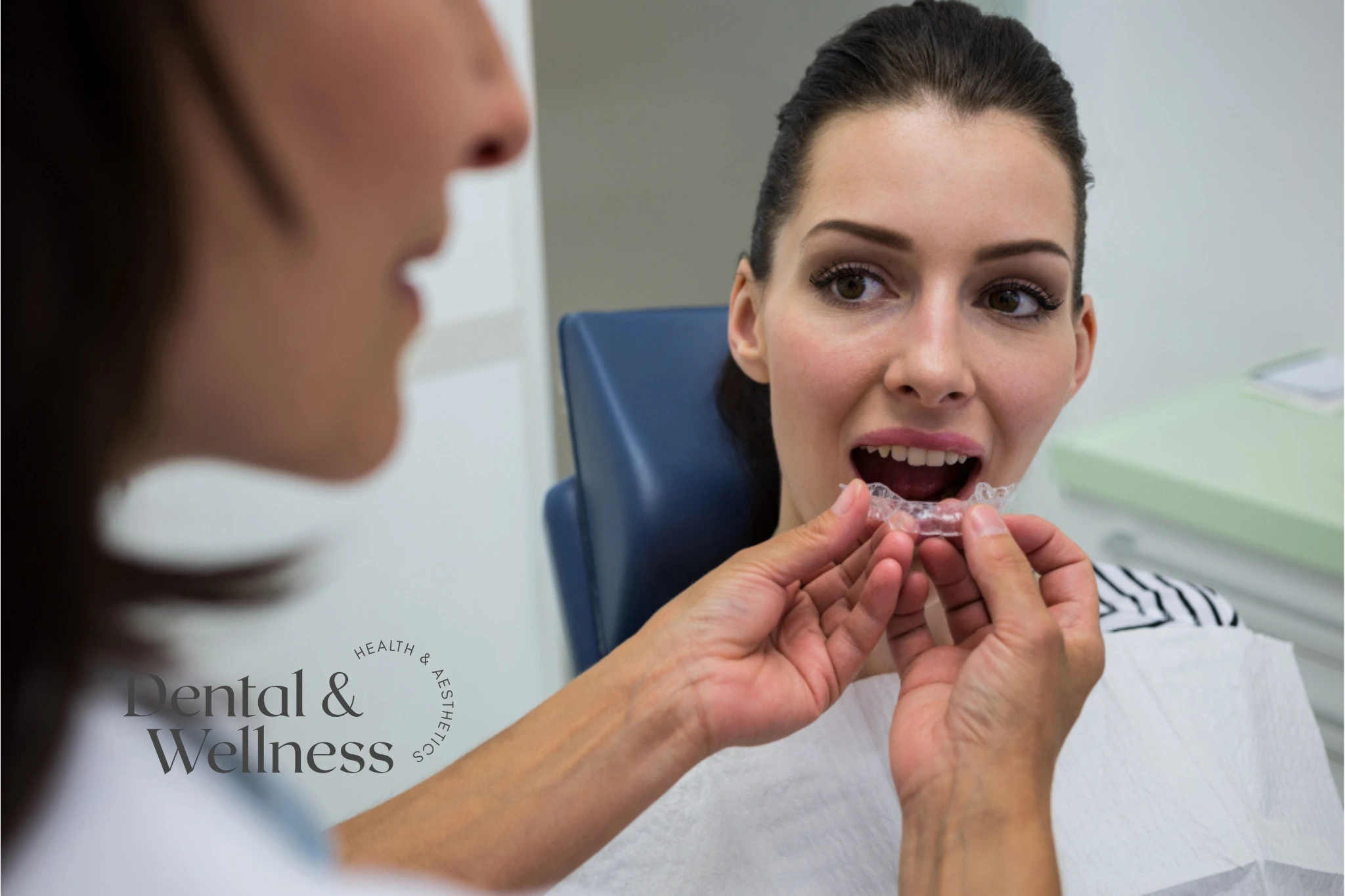 Dentist fitting a clear aligner for a patient in the chair