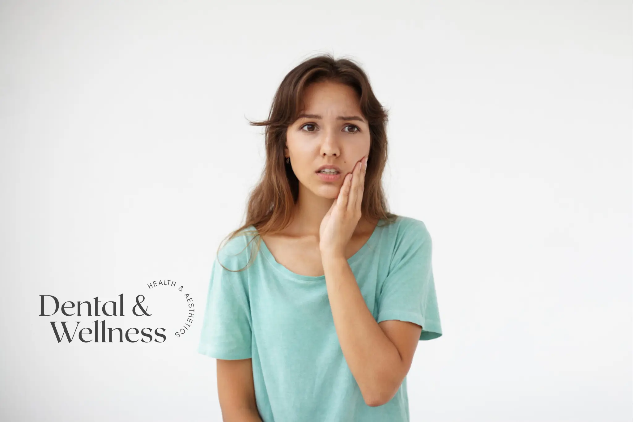 Young woman holding her cheek with a worried expression — emergency tooth extraction