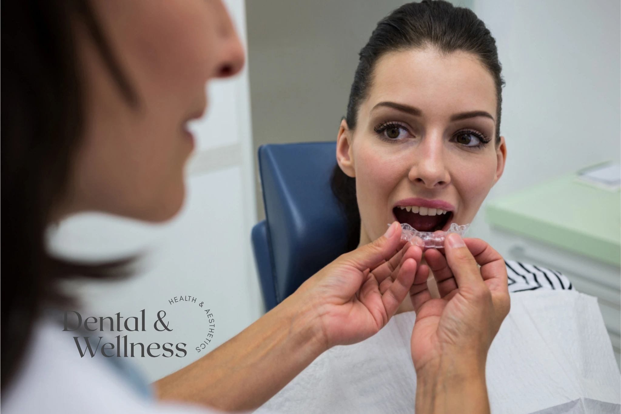 Dentist fitting a clear aligner for a patient in the chair
