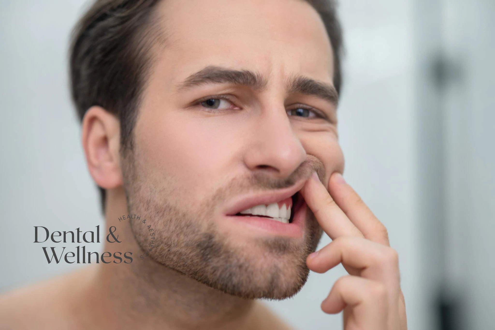 Bleeding gums: man grimacing and touching his lower lip