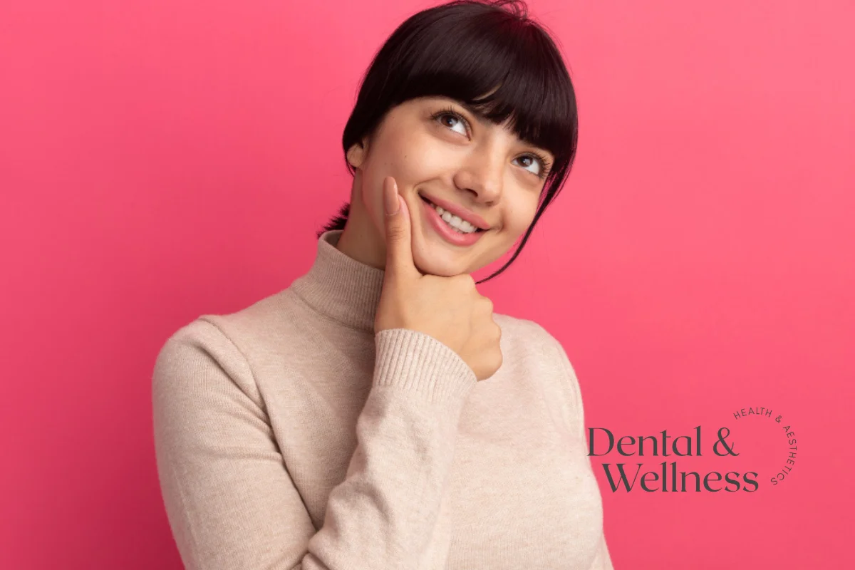 Smile line treatment: smiling woman resting her chin on her hand against a pink background