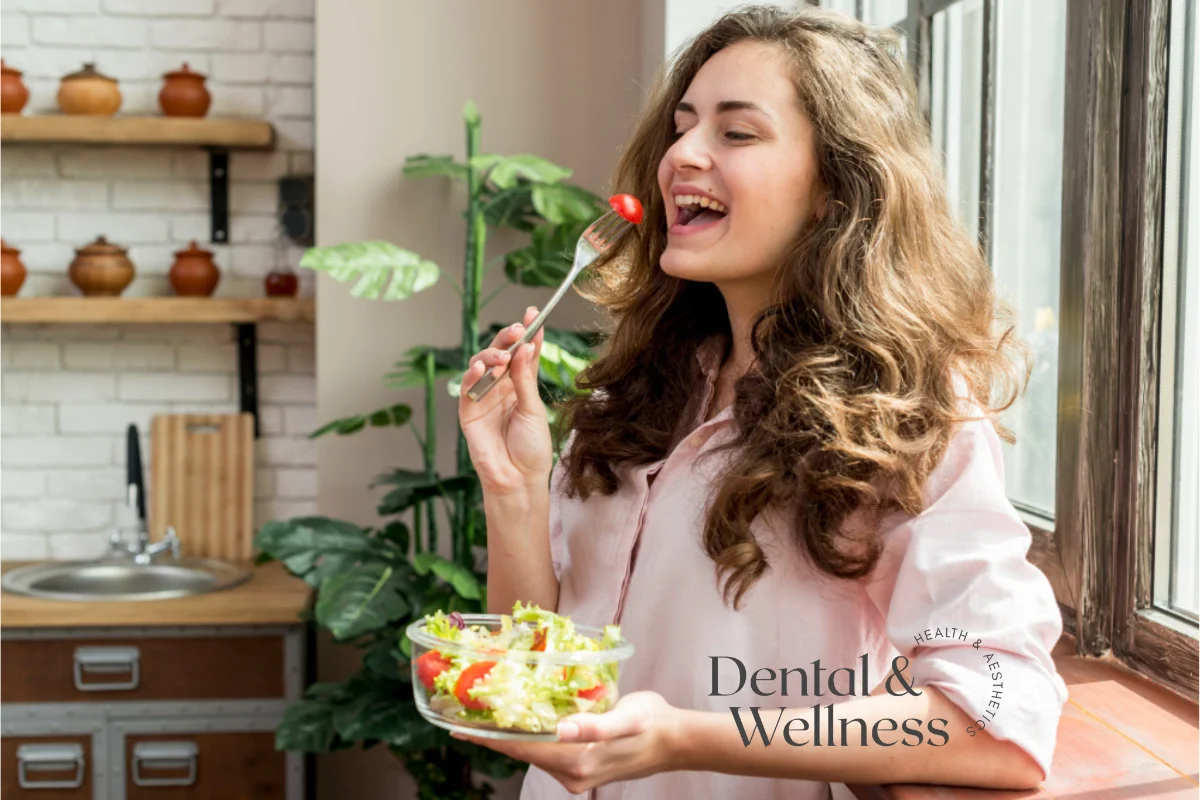 Smiling woman eating a fresh salad in her kitchen