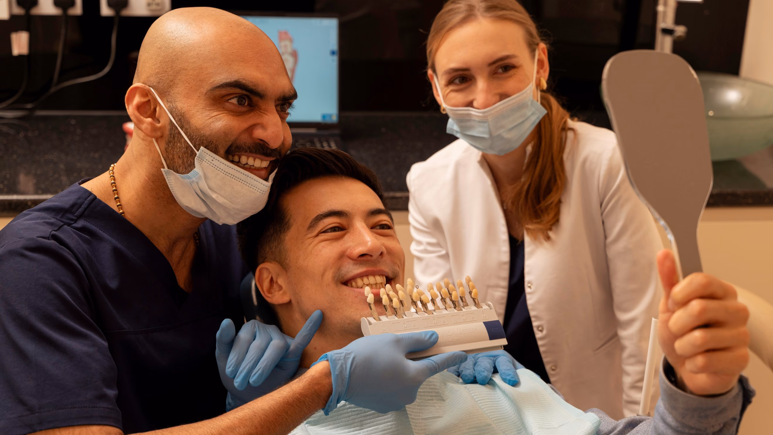 Porcelain veneers in Islington, London: dentist and nurse matching a veneer shade guide against a smiling patient's teeth