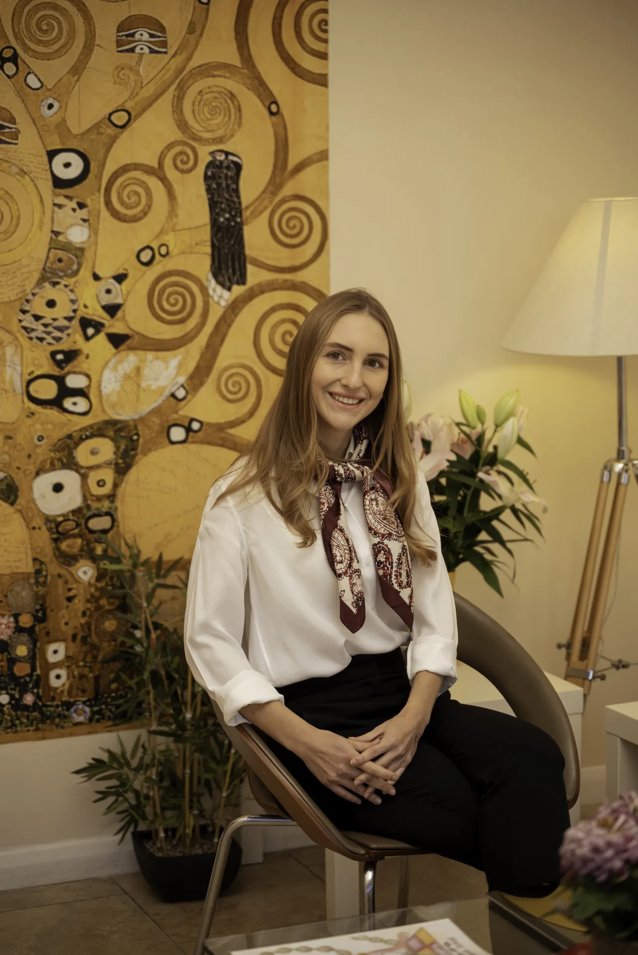 Wellness practitioner seated in the clinic lounge — transformational coaching