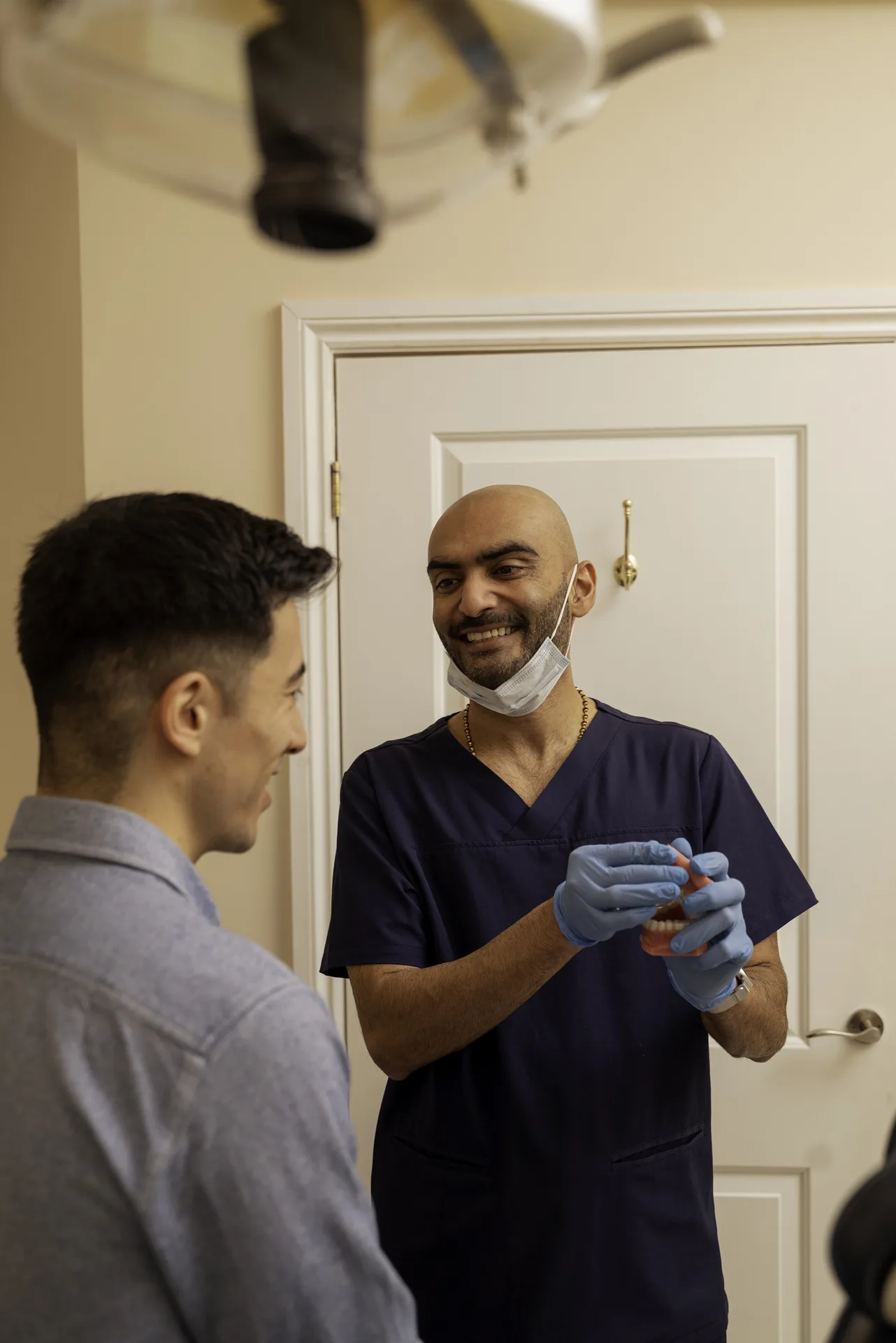 Dentist talking with a patient at the door of the treatment room