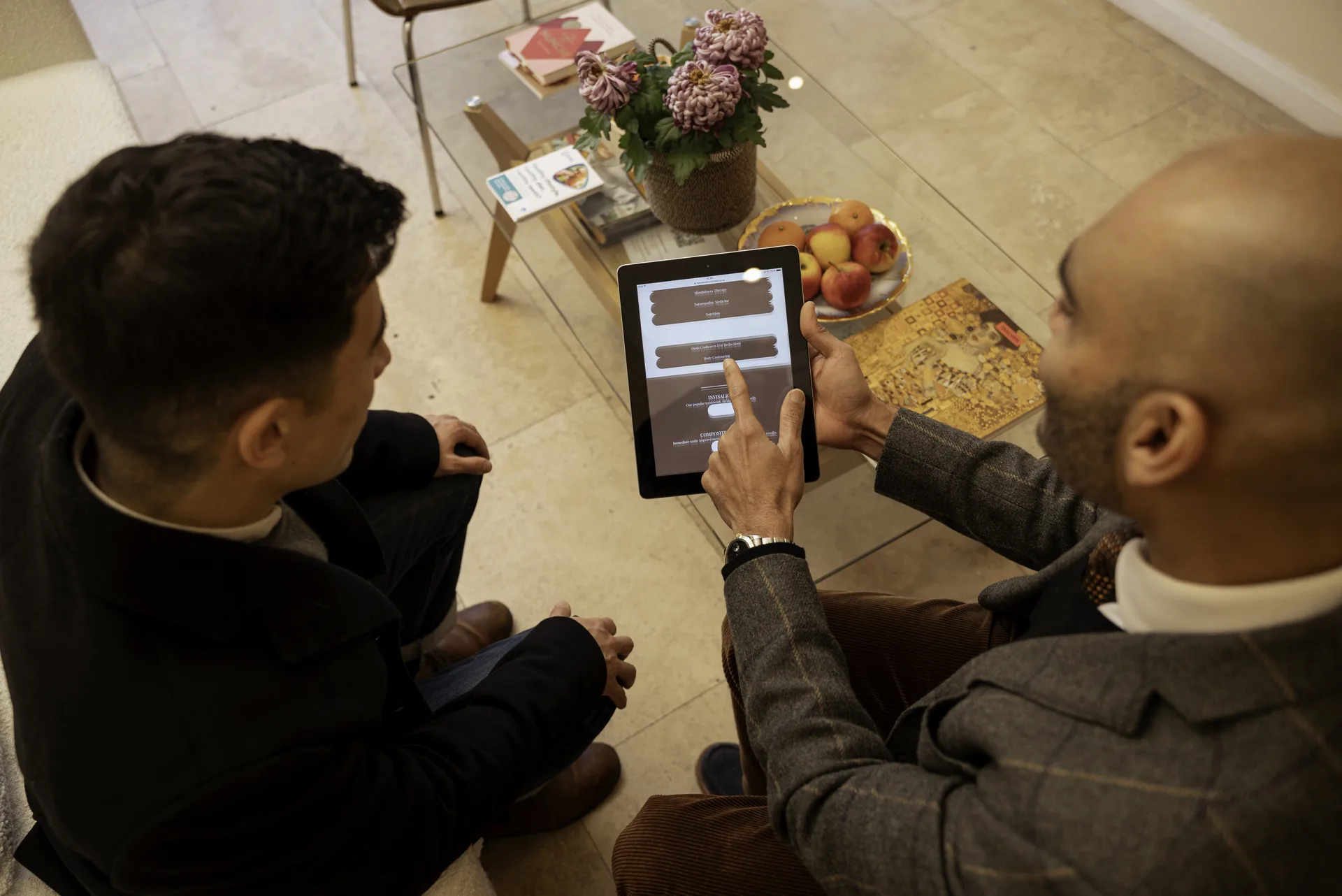 Clinician talking a patient through a treatment plan on a tablet in the clinic lounge — anti-snoring devices