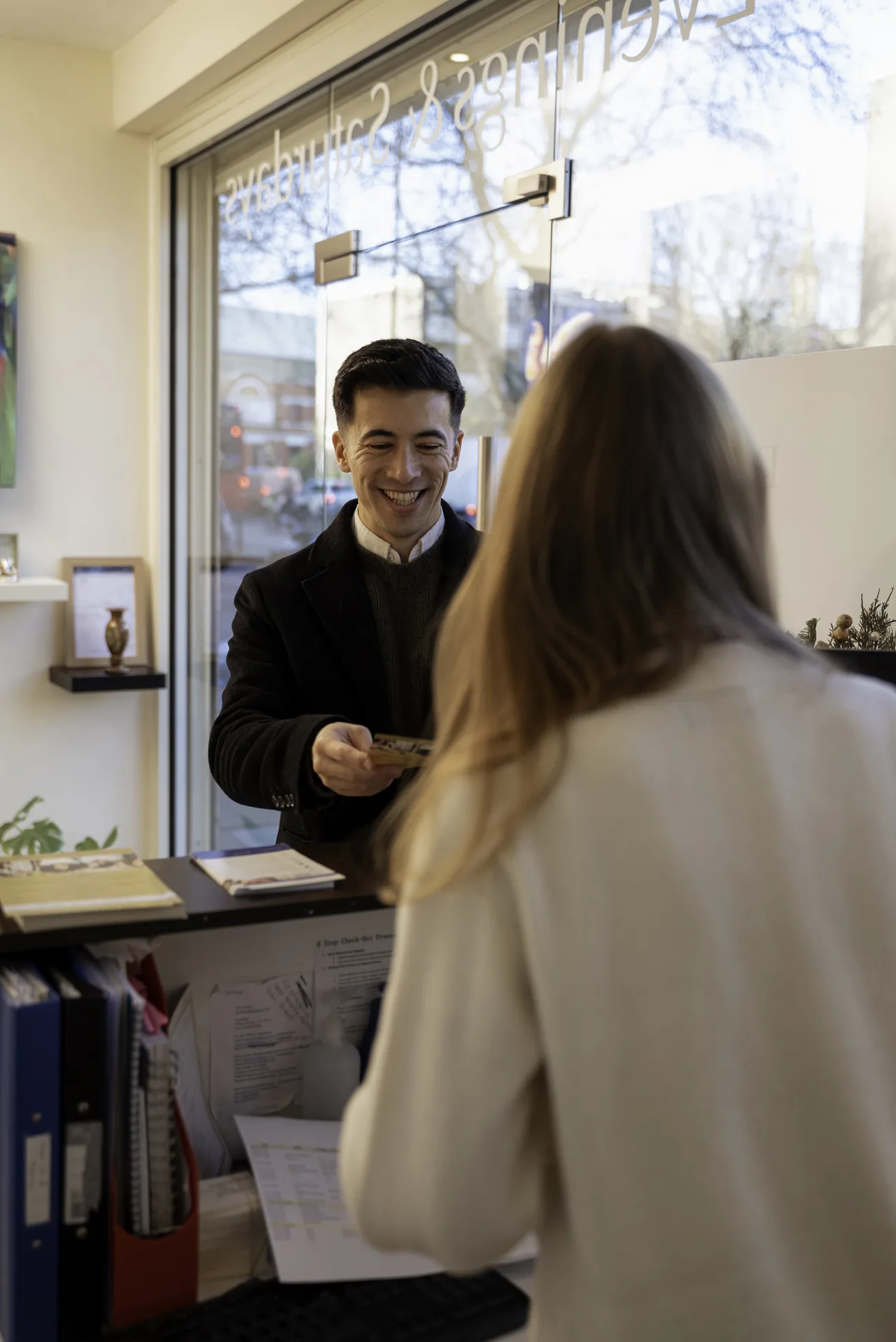 Receptionist welcoming a patient at the front desk — dentist near Angel