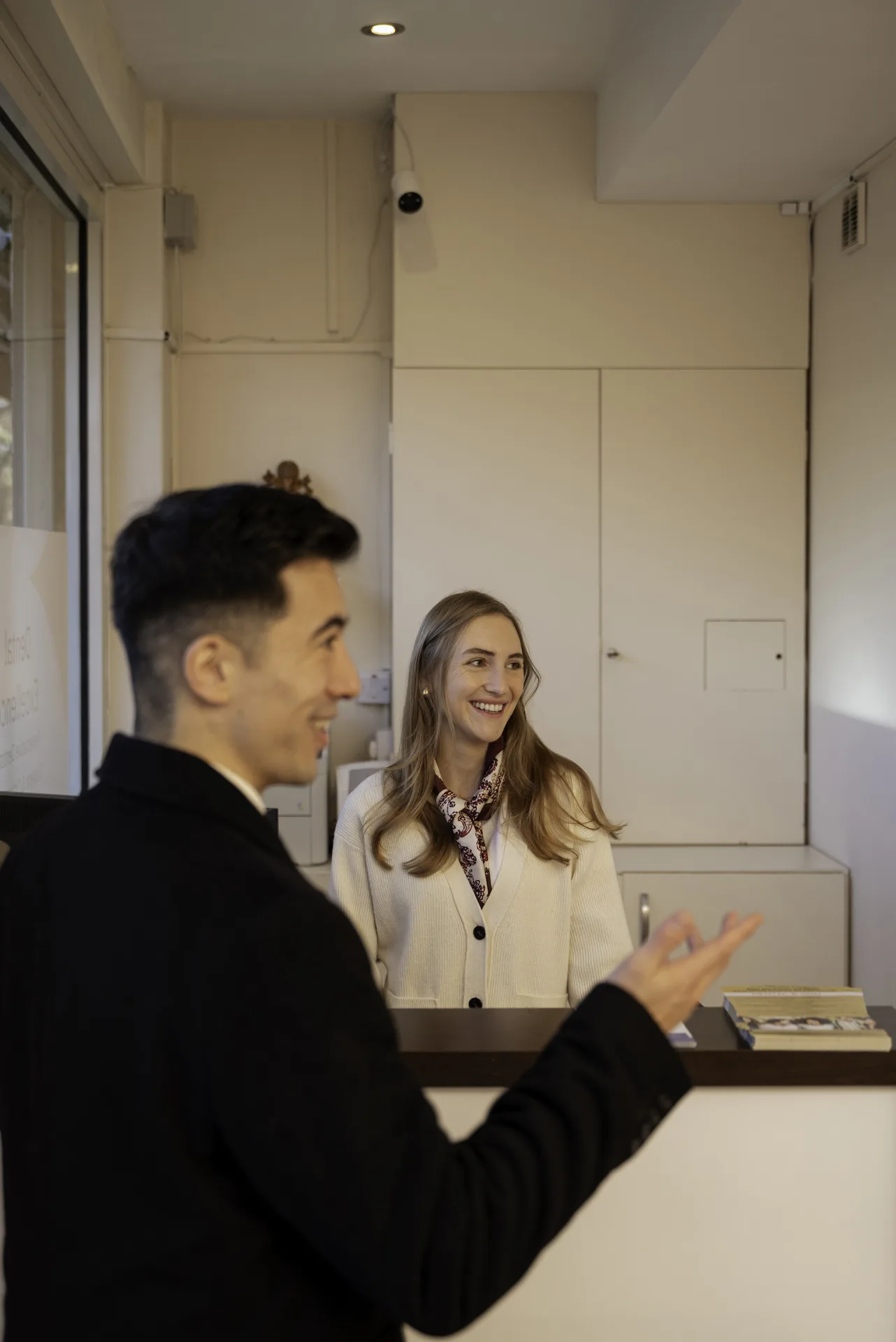 Receptionist greeting a patient at the front desk — dentist for Shoreditch