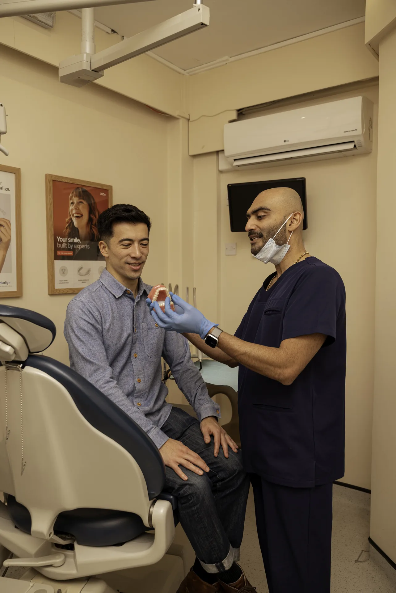 Immediate vs delayed implants: dentist examining a standing patient's mouth in the treatment room