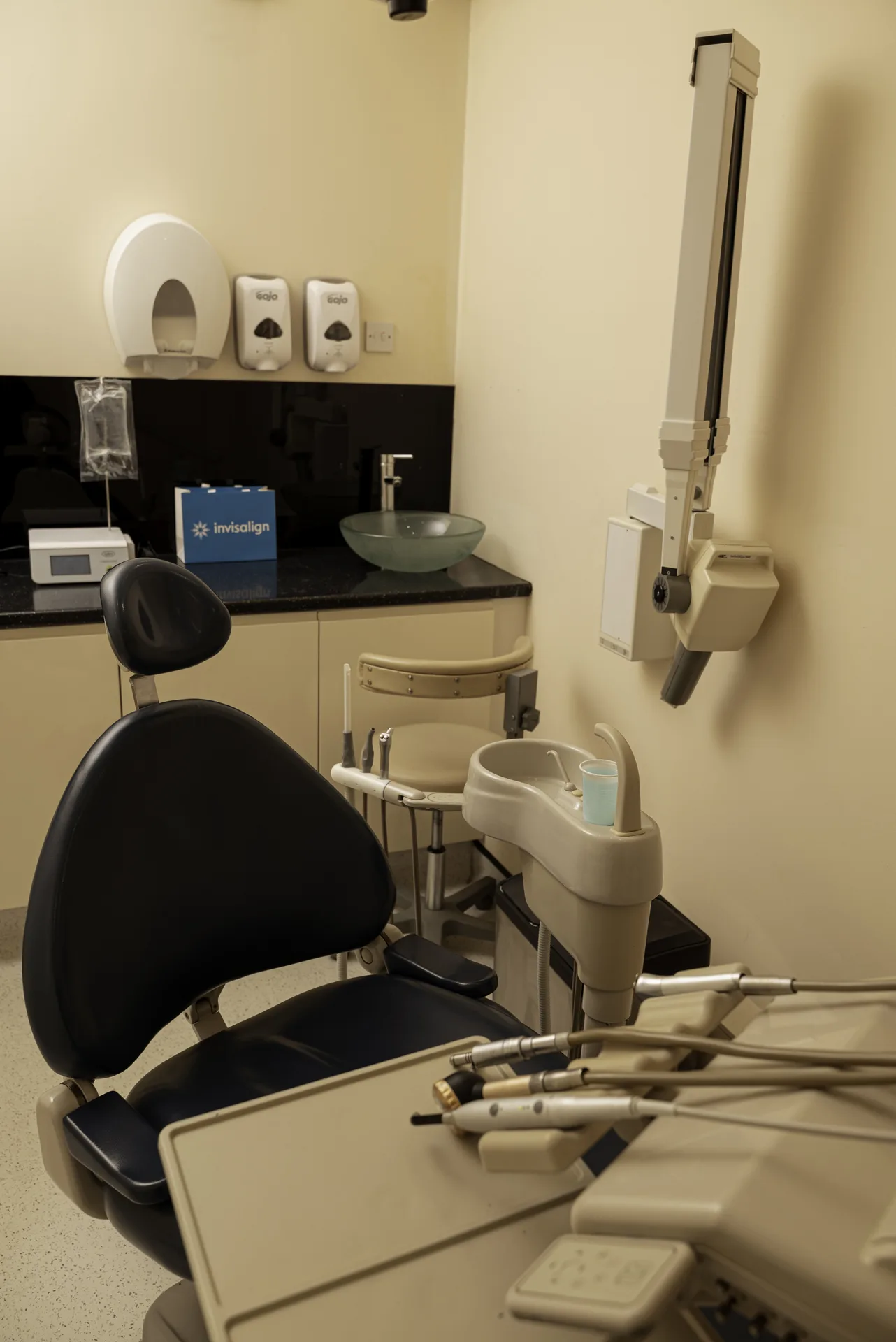Dental chair and equipment in an empty treatment room — implant vs bridge