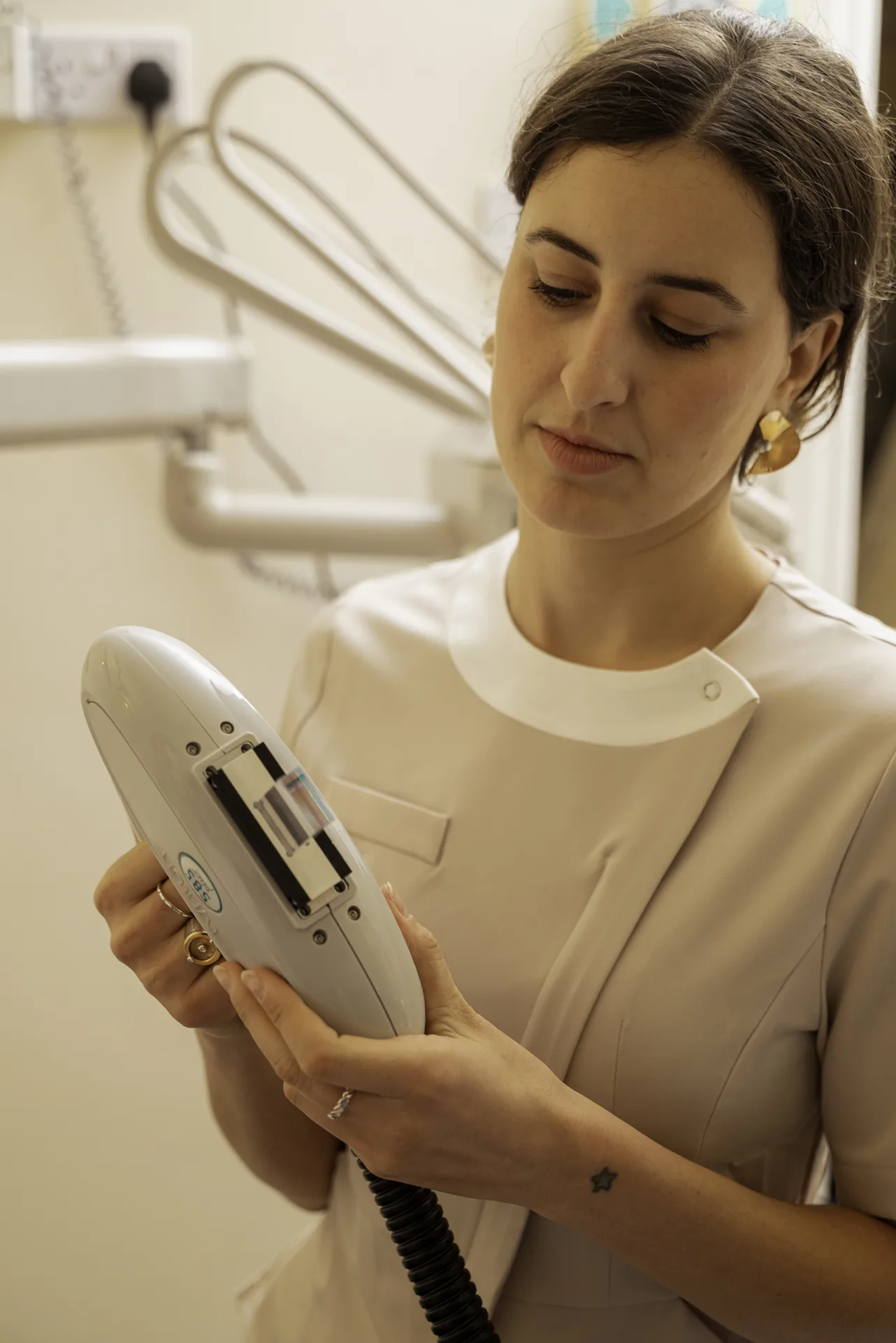 Q-Switch vs picosecond laser: therapist holding a laser handpiece in a treatment room