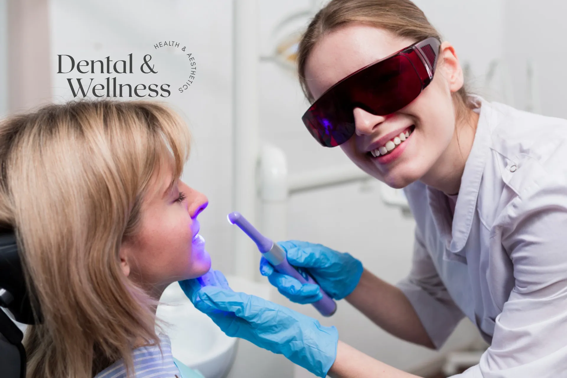 Laser teeth whitening: clinician in protective glasses using a whitening light on a patient's teeth