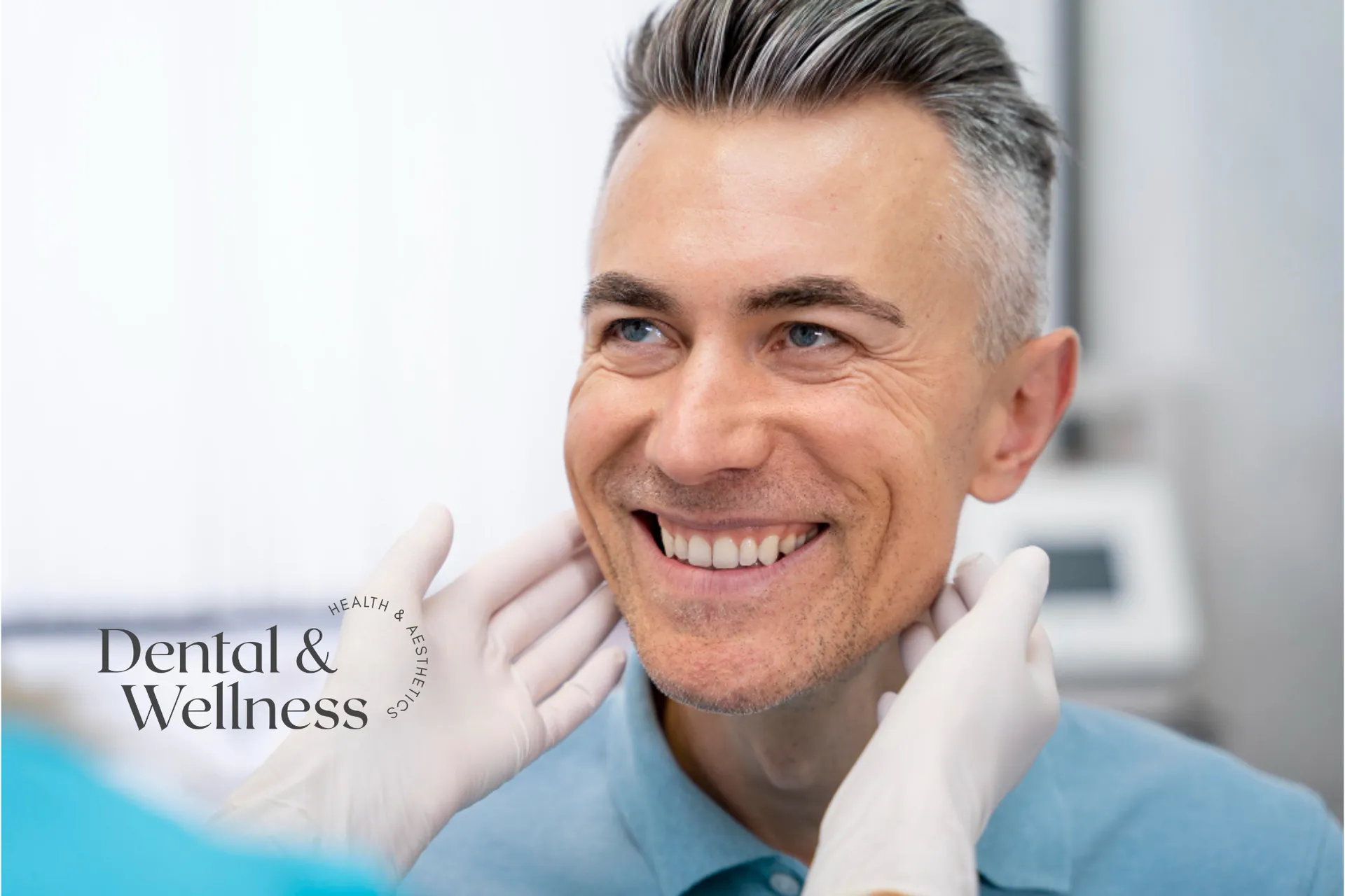 Full mouth dental implants: smiling grey-haired man having his jaw checked by a gloved clinician